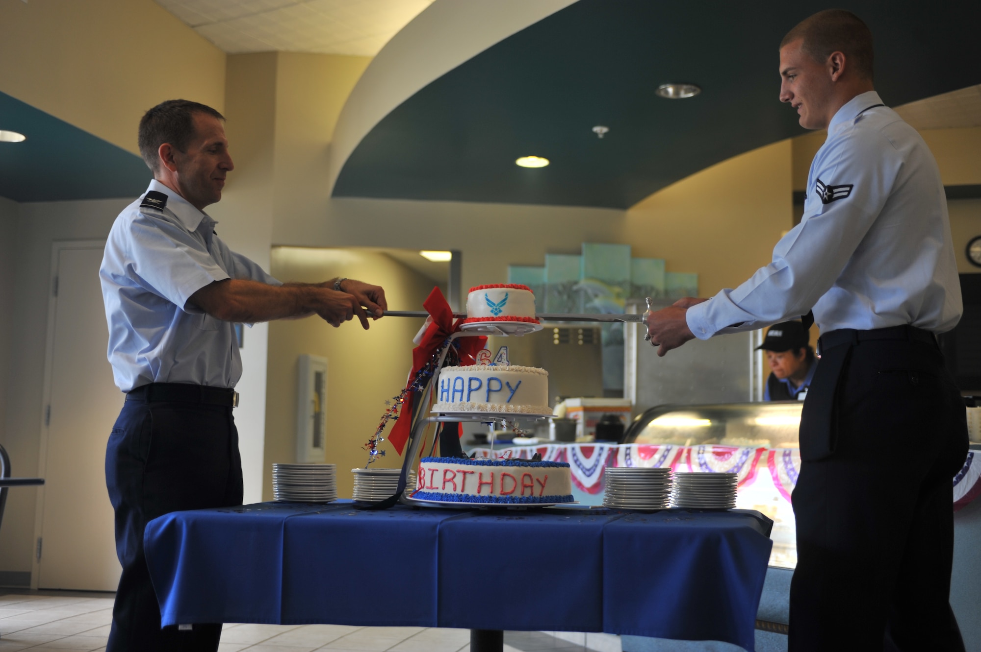 Col. James Slife, commander of the 1st Special Operations Wing, left, and Airman 1st Class Preston Harris, a Tactical Air Control Party candidate, use a ceremonial sword to cut a birthday cake marking the Air Force’s 64th birthday during a celebration at the Riptide Dining Facility at Hurlburt Field, Fla., Sept. 19, 2011. Slife and Harris participated in a military tradition in which both the most senior and most junior ranking Airmen in attendance cut the first slice of cake together. (U.S. Air Force Photo/Airman 1st Class Hayden K. Hyatt/ Released)