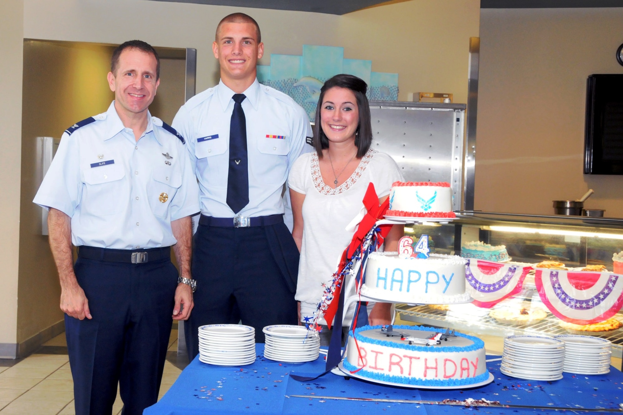 Col. James Slife, commander of the 1st Special Operations Wing, Airman 1st Class Preston Harris, a Tactical Air Control Party candidate, and Jacquelyn Harris pose next to a birthday cake marking the Air Force's 64th birthday at the Riptide Dining Facility at Hurlburt Field, Fla., Sept. 19, 2011. The Air Force officially became its own branch within the Department of Defense Sept. 18, 1947. (Courtesy photo by Barbara Fuller)