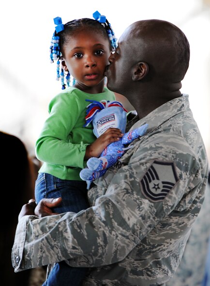 A U.S. Air Force 79th Fighter Squadron master sergeant, kisses his daughter before deploying, Shaw Air Force Base, S.C., Sept. 19, 2011. Multiple squadrons gathered in Hanger 1200 with their fellow Airmen and family members before deploying. (U.S. Air Force photo by Airman 1st Class Tabatha Duarte/Released)