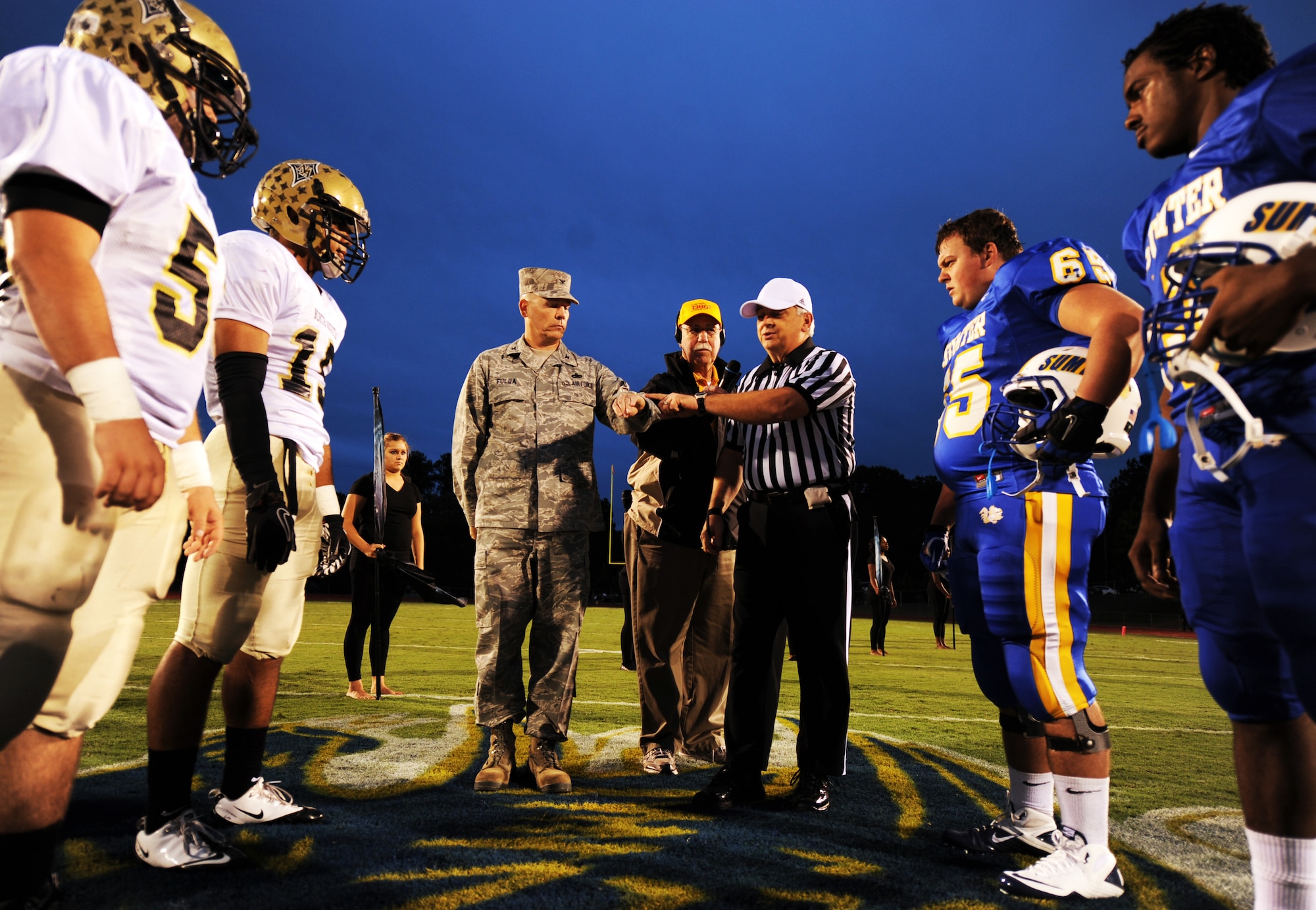 U.S. Air Force Col. Walter Fulda, 20th Mission Support Group commander, holds out the coin to decide which team calls the first play before the Sumter versus North Augusta High School game at Sumter High School Football Stadium, S.C., Sept. 16, 2011 Sumter High School held a Military appreciation night where Shaw Air Force Base Honor Guard posted the 'Colors' and Mr. John Kennedy, 20th Force Support Squadron school liaison officer sang the National Anthem. (U.S. Air Force photo by Airman 1st Class Tabatha Duarte/Released)