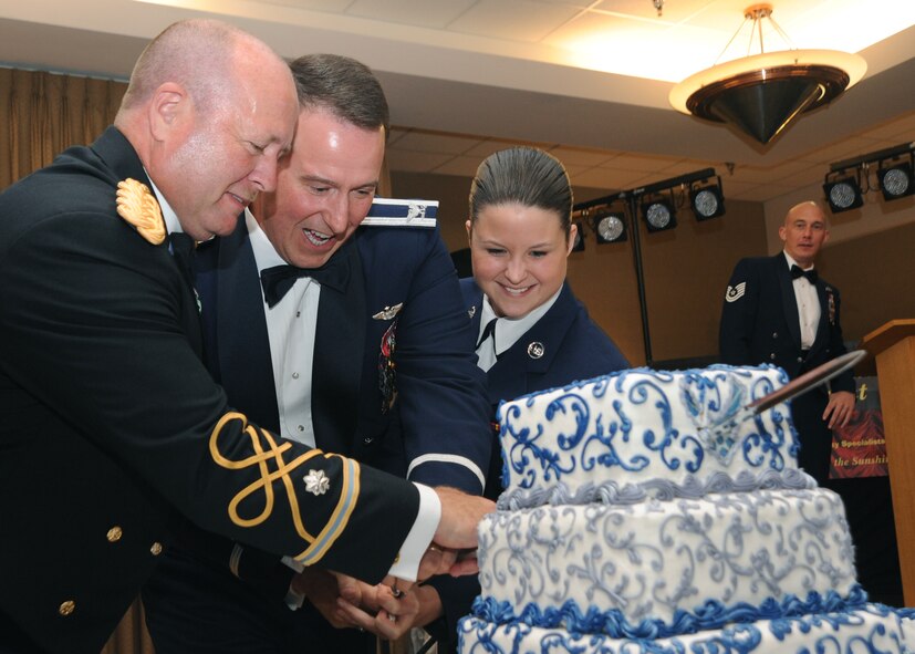 (Left to right) Lt. Col. Joseph George, Col. Timothy Bush, 319th Air Base Wing commander and Airman 1st Class Kaitlynn Grear cut the cake during the Air Force Ball at Grand Forks Air Force Base Sept. 17, 2011. The oldest and youngest member join the colonel in the tradition of the cutting the cake. The Air Force Ball is an annual Air Force-wide tradition to celebrate the heritage and history of the birthday of the Air Force. (U.S. Air Force photo by Senior Airman Amber E. Bennett)