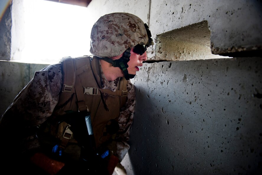 A U.S. Marine Corps member with the 2nd Tank Battalion out of Marine Corps Base Camp Lejeune, N.C., looks through the opening of a makeshift building during exercise Atlantic Strike 11-02 at Avon Park Air Force Range, Fla., Sept. 13, 2011. During the training scenario, a team of Marines engaged simulated opposing forces mimicking tactics seen downrange. Their job was to eliminate the opposing forces while providing support to U.S. Air Force joint terminal attack controllers. (U.S. Air Force photo by Staff Sgt. Jamal D. Sutter/Released)
