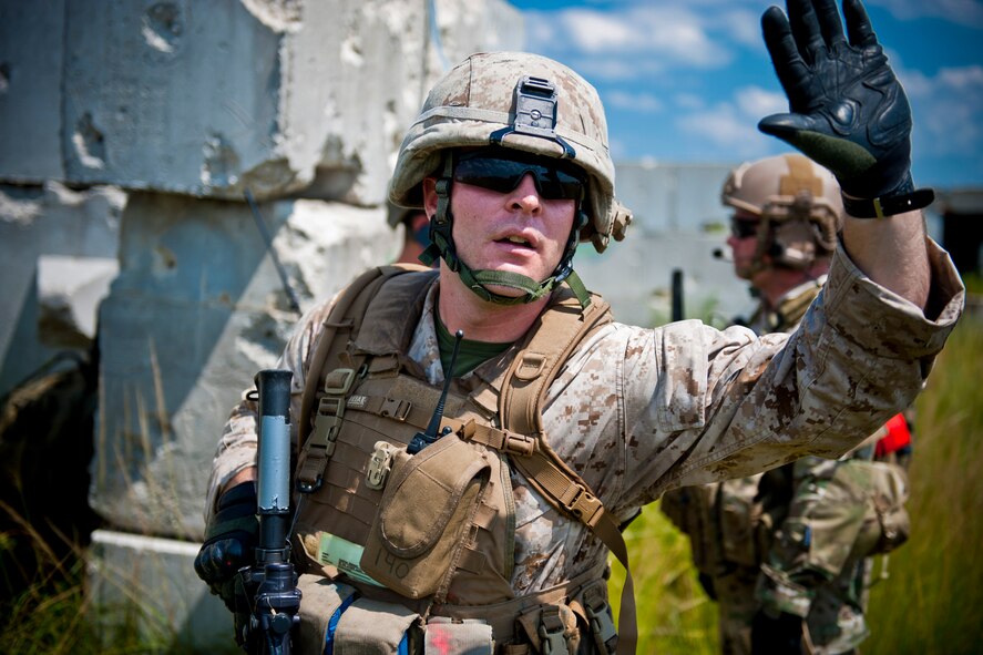 U.S. Marine Corps Sgt. Shelby Mangiaracina, 2nd Tank Battalion section leader, signals his team members during exercise Atlantic Strike 11-02 at Avon Park Air Force Range, Fla., Sept. 13, 2011. During the training scenario, Mangiaracina performed ground-forces commander duties and led his team after an attack by opposing forces. He also stayed in direct communication with U.S. Air Force joint terminal attack controllers who directed close air support against enemies. (U.S. Air Force photo by Staff Sgt. Jamal D. Sutter/Released)