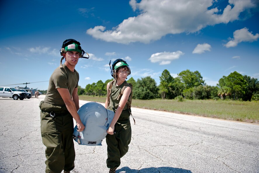 U.S. Marine Corps Cpls. Pizana Louis and Brianna Consorti, Marine Light Attack Helicopter Squadron 467 avionics technicians out of Marine Corps Air Station Cherry Point, N.C., carry a Forward Looking Infrared Radar (FLIR) ball during Exercise Atlantic Strike 11-02 at Avon Park Air Force Range, Fla., Sept. 12, 2011. When mounted to helicopters, the FLIR ball captures and collects temperature data and images. It also provides the exact coordinates of targets. The USMC participated in Atlantic Strike to aid joint terminal attack controllers training on possible real world war time situations. (U.S. Air Force photo by Staff Sgt. Jamal D. Sutter/Released) 