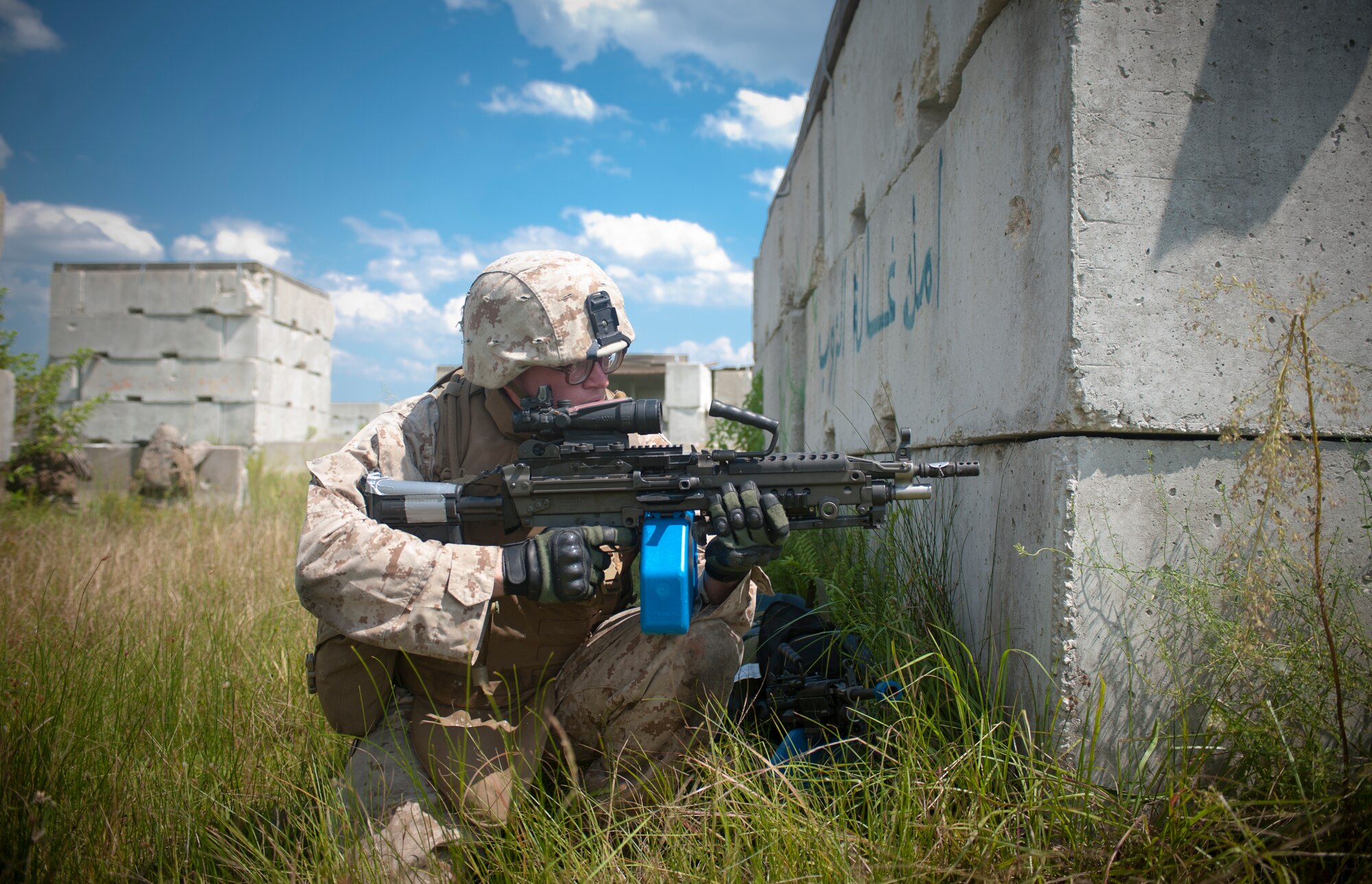 U.S. Marine Corps Pfc. Jacob York, 2nd Tank Battalion anti-tank missileman, looks out from behind a corner to cover his squad while bounding back out of a village during a training scenario Sept. 13, at Avon Park Air Force Training Range. The Marines drove into the village in Humvees then moved on foot through the village to eliminate the opposition force. (U.S. Air Force photo by Airman 1st Class Jarrod Grammel/Released)
