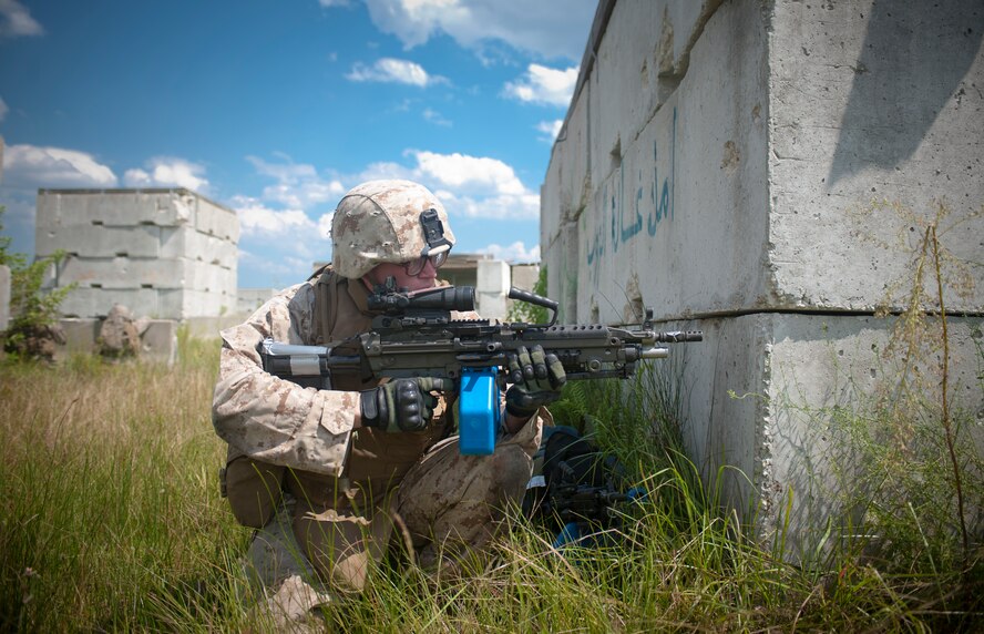 U.S. Marine Corps Pfc. Jacob York, 2nd Tank Battalion anti-tank missileman, looks out from behind a corner to cover his squad while bounding back out of a village during a training scenario Sept. 13, at Avon Park Air Force Training Range. The Marines drove into the village in Humvees then moved on foot through the village to eliminate the opposition force. (U.S. Air Force photo by Airman 1st Class Jarrod Grammel/Released)
