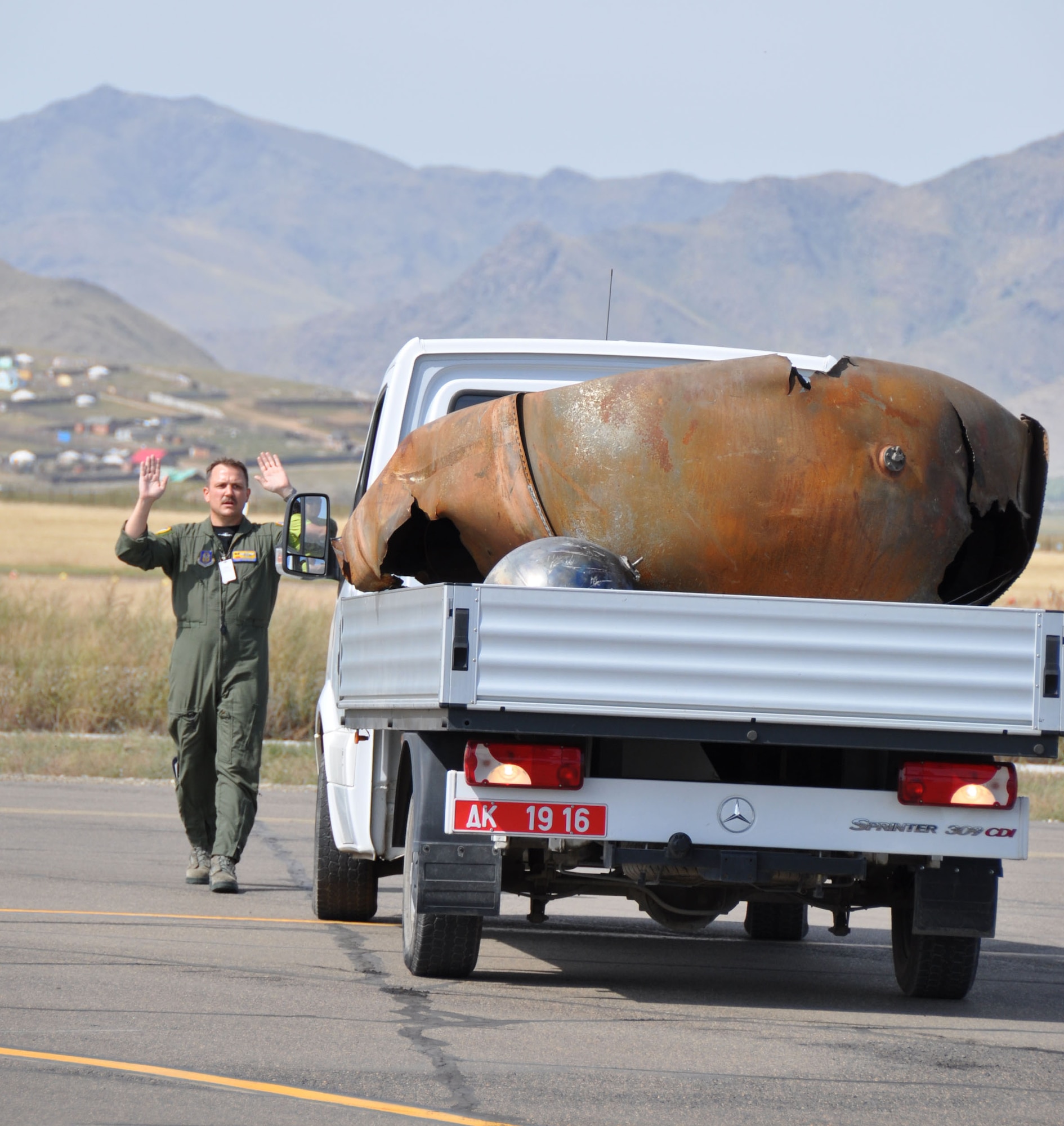 Tech. Sgt. Ronald Dunn, 729th Airlift Squadron loadmaster, guides a Mongolian driver who is backing the truck toward an Air Force Reserve C-17 Globemaster III in Mongolia, Aug. 26.  Dunn was part of a crew from March Air Reserve Base, Calif., who were assigned to a mission to retrieve space debris that fell to earth last summer.  The parts were identified as expended rocket parts from an Air Force missile launched into space nearly a decade ago.  (U.S. Air Force photo/Master Sgt. Linda Welz)