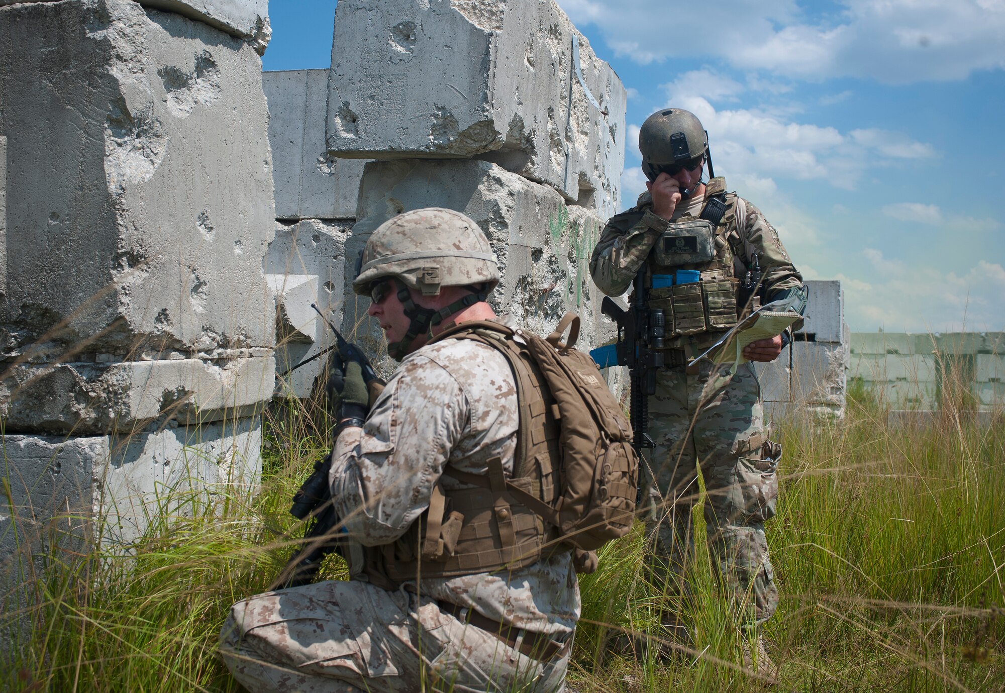 U.S. Air Force Senior Airman Jess Hager, 11th Air Support Operations Squadron joint terminal attack controller, and U.S. Marine Corps Sgt. Shelby Mangiaracina, 2nd Tank Battalion section leader, look over maps and coordinate with aircrew to provide close air support during Exercise Atlantic Strike Sept. 13, at Avon Park Air Force Training Range. Atlantic Strike gave JTACs, who typically work with Army joint fires observers, a chance to train with Marine air naval gunfire liaisons.  (U.S. Air Force photo by Airman 1st Class Jarrod Grammel/Released)
