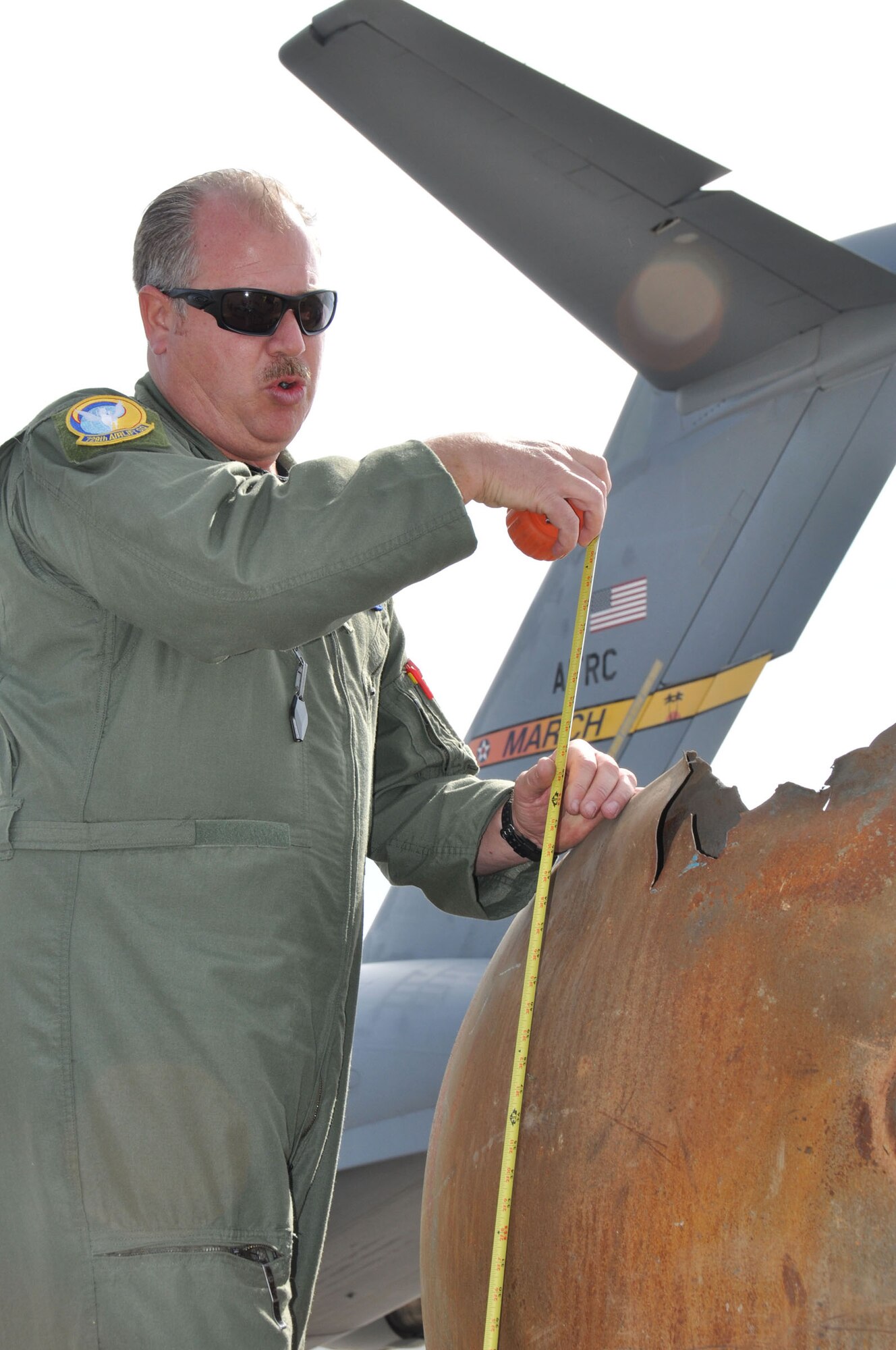Master Sgt. Lance Augustine, a 729th Airlift Squadron loadmaster, measures the dimensions of an expended  stage II rocket in Mongolia, Aug. 26, 2011.  Augustine was part of a 15-person Air Force Reserve crew that departed from March Air Reserve Base, Calif.,  on a mission to Mongolia to retrieve fallen satellite parts for NASA.  (U.S. Air Force photo/Master Sgt. Linda Welz)