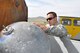 At the Chinngis Khaan International Airport, Tech. Sgt. John Lowe, 50th Aerial Port Squadron, inspects a satellite rocket's expended hydrogen tank, Aug. 26, 2011.  The tank and two other pieces of debris fell onto Mongolian soil after orbiting the Earth for nearly a decade. (U.S. Air Force photo/Master Sgt. Linda Welz)