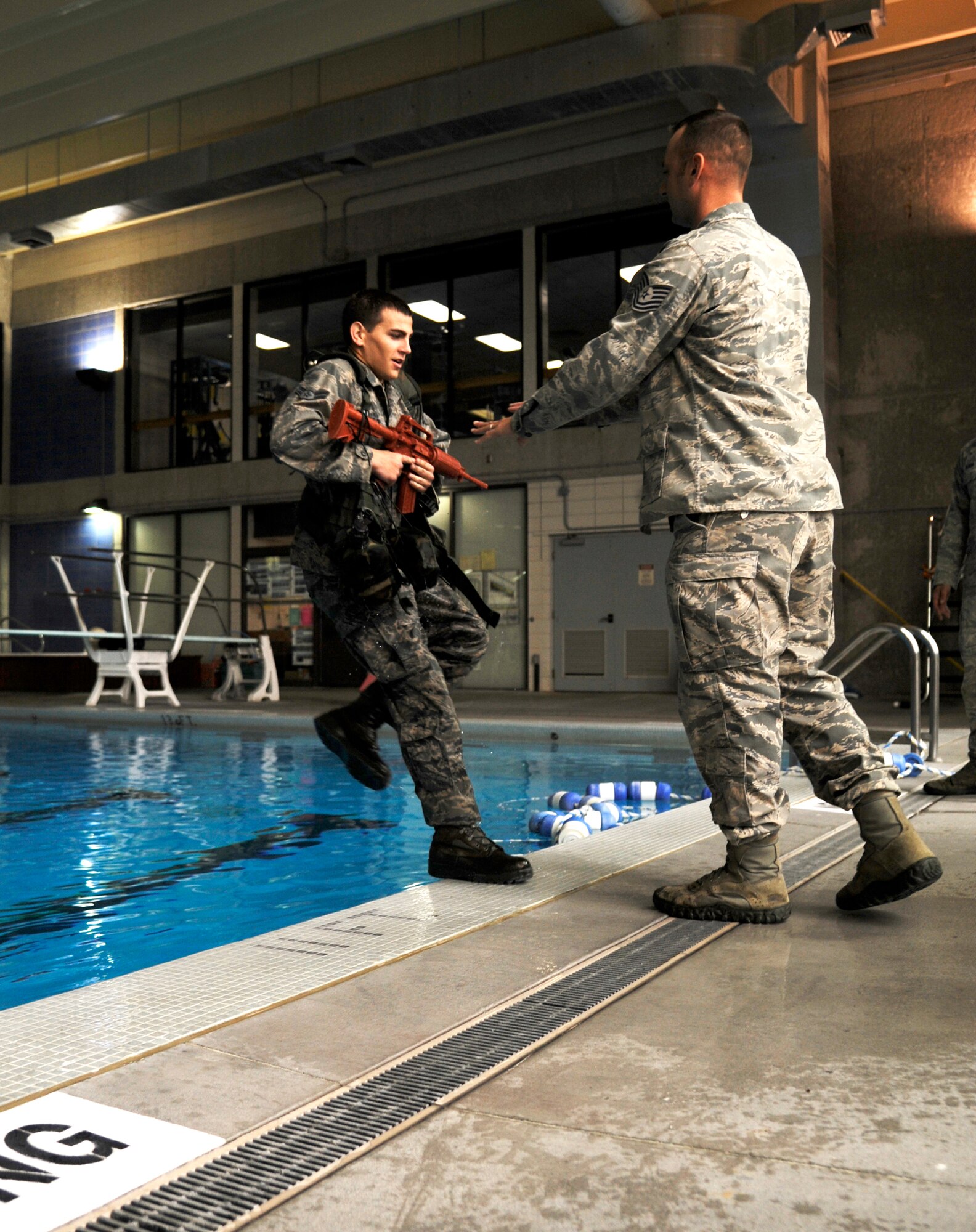 WARRENSBURG, Mo. - Airman 1st Class Andrew Timler, 509th Security Forces Squadron member, is shoved in a pool by Tech. Sgt. during water-survival training at the Warrensburg Recreation Center Sept. 15. These Airmen are brushing up on skills needed to get a recommendation to the Air Force Pre-Ranger Course. The Airman that shows the most leadership abilities and highest physical and mental endurance throughout training will be sent. (U.S. Air Force photo by Senior Airman Cody H. Ramirez)
