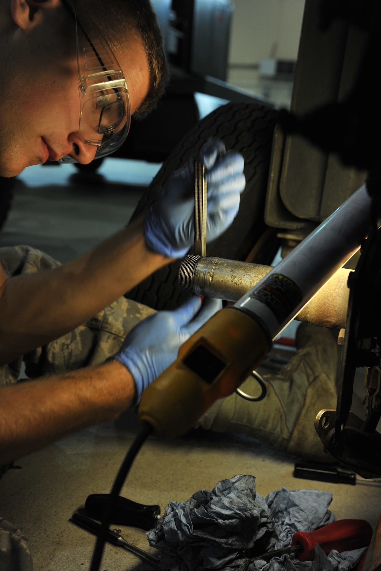 RAF MILDENHALL, England – Airman David Stribling, 100th Maintenance Squadron Aerospace Ground Equipment journeyman, cleans the threading prior to changing a wheel-bearing here Sept. 20, 2011. The AGE craftsmen perform regularly scheduled maintenance to ensure that all equipment is functioning properly. (U.S. Air Force photo by Senior Airman Jerilyn Quintanilla)