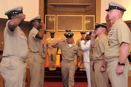 Sideboys salute Chief Machinist’s Mate Christopher Huggins as he is piped aboard the Chief's mess after receiving his anchors during the Chief Petty Officer Pinning Ceremony held at Joint Base Charleston-Weapons Station Sept. 16. Huggins is assigned to the Naval Consolidated Brig Charleston. (U.S. Navy photo/Mass Communication Specialist 1st Class Jennifer Hudson)