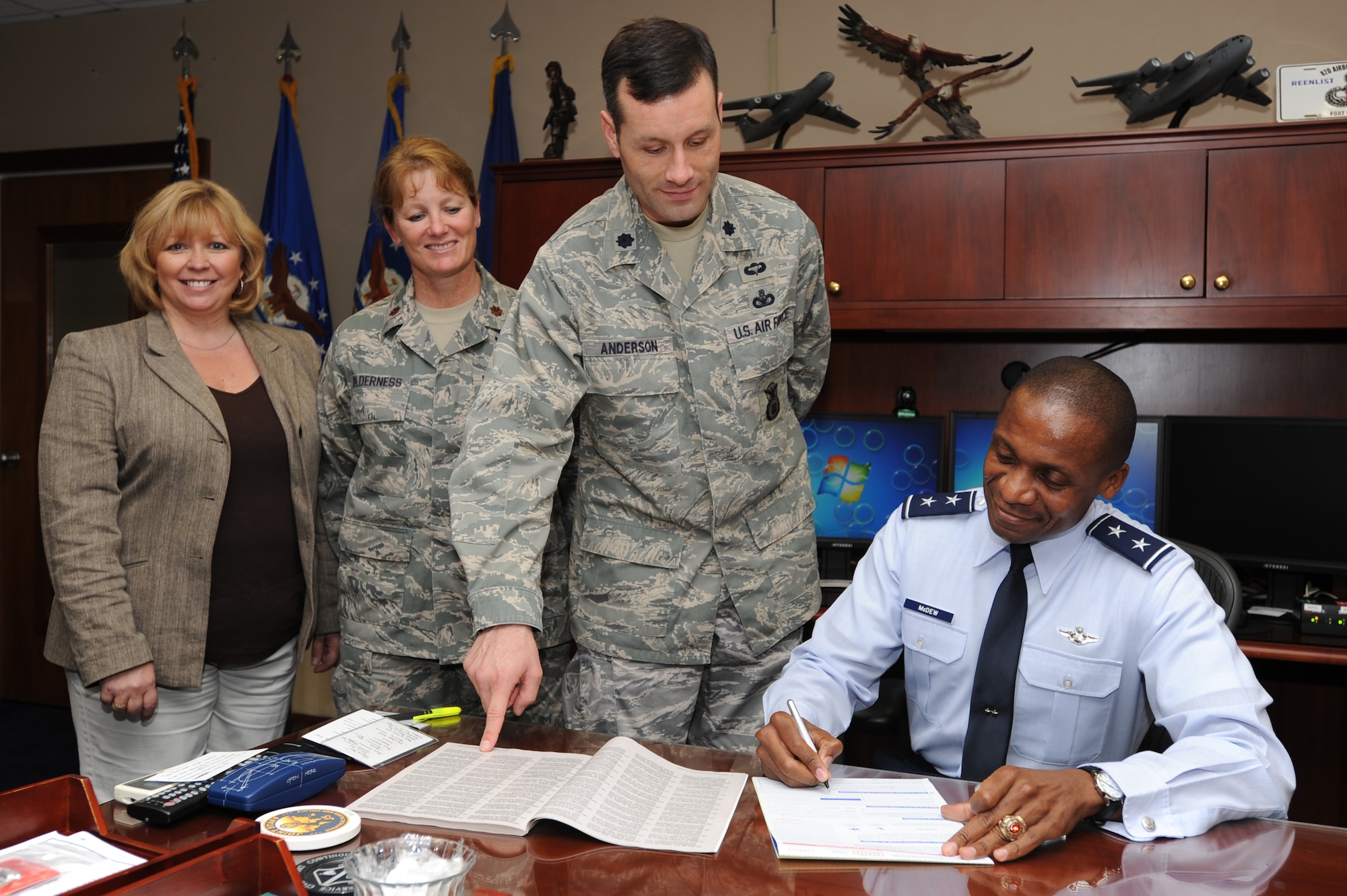 Maj. Gen. Darren McDew, Air Force District of Washington commander, signs his Combined Federal Campaign contribution form Sept. 20 on Joint Base Andrews, Md. as campaign leads (left to right) Juli Luke, AFDW protocol; Maj. Michele Holderness, 779th Medical Operations Squadron; and Lt. Col. Gregory Anderson, 11th Security Forces Squadron commander, look on. Pledges made by Federal civilian and military contributors during the campaign season support eligible non-profit organizations that provide health and human service benefits throughout the world. (U.S. Air Force photo by Staff Sgt. Christopher Ruano)