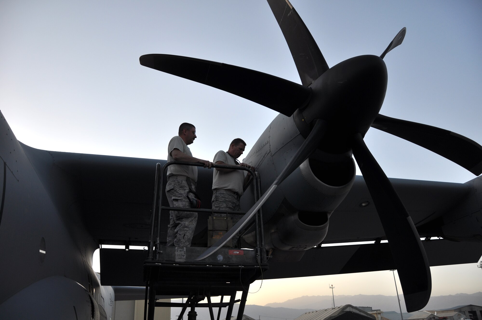 BAGRAM AIRFIELD, Afghanistan -- Senior Airman James Mitchell removes an engine cowling on a C-130J Hercules aircraft from the 774th Expeditionary Airlift Squadron here Sept. 20, 2011, as Tech. Sgt. Wayne Warner looks on. Both Airmen are 774 EAS maintainers. Mitchell hails from North Kingston, R.I., while Warner is a native of Warwick, R.I. (U.S. Air Force photo/Staff Sgt. John Wright)