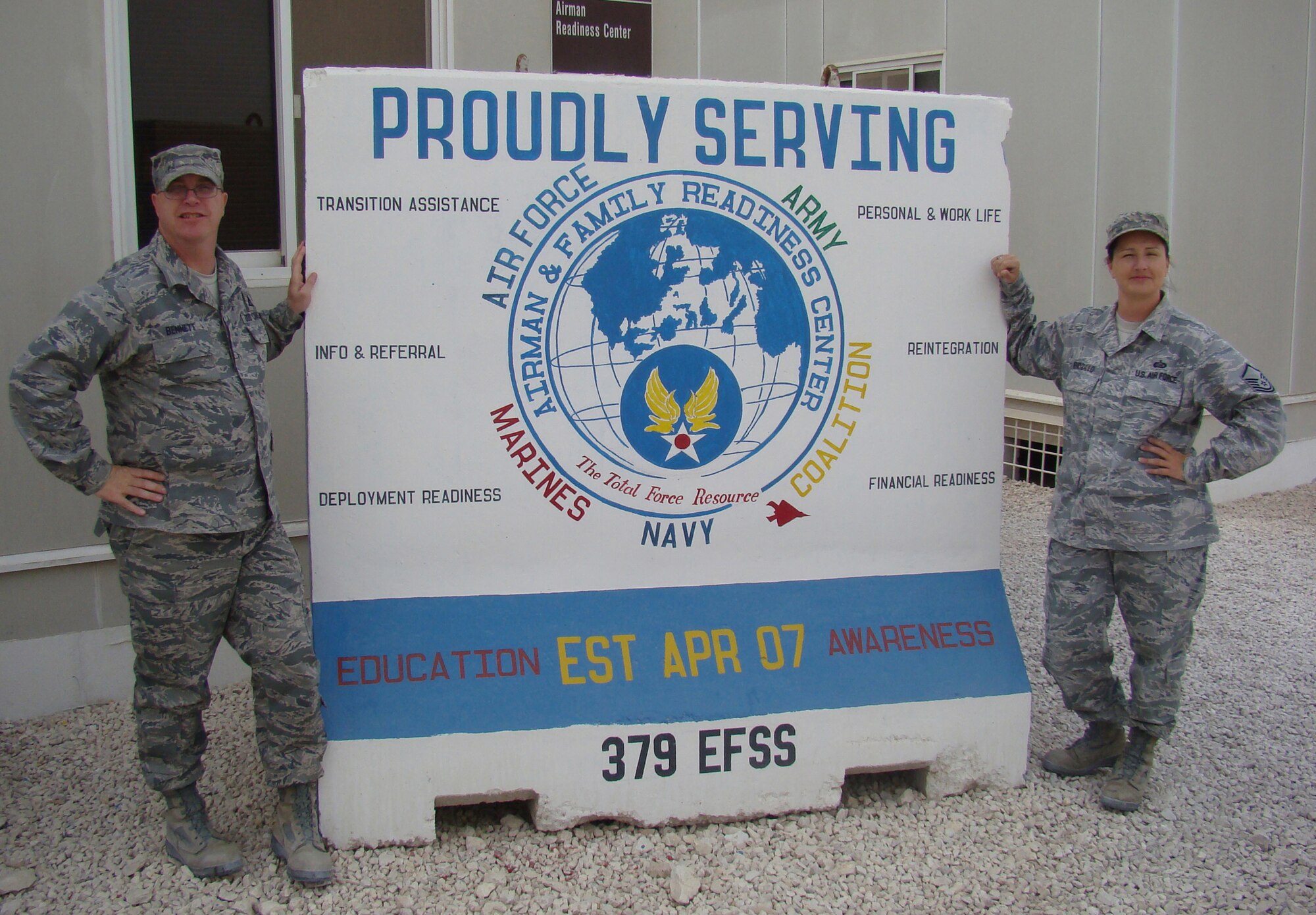 SOUTHEAST ASIA -- (Right) Master Sgt. Mona Wendzillo, 509th Force Support Squadron NCO in charge of Airman & Family Readiness Center, and Mr. Brian Bennett, 92nd Force Support Squadron, stand near the A&FRC sign during her deployment. Wendzillo aided in creating a self-sufficient and mission ready community through individual and family preparedness. (Courtesy photo)