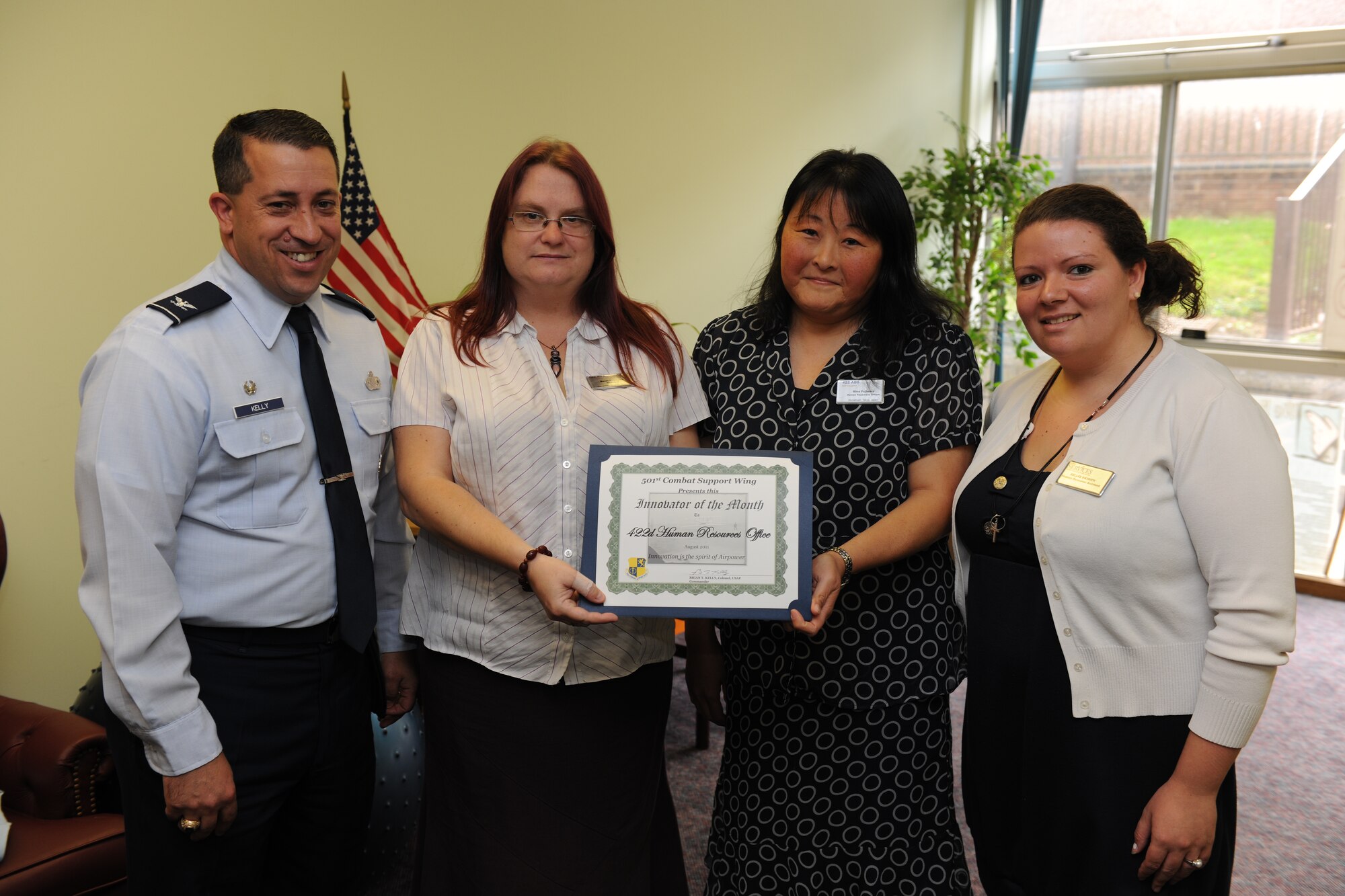 RAF CROUGHTON, United Kingdom - Col. Brian Kelly presents the Innovator of the Month award to the 422nd Human Resources Office. From left to right, Sarah Zdyrko, Mina Fujiwara and Kellee Patrick helped revise training, which will save NAF employees more than 80 hours of time. (U.S. Air Force photo by Tech. Sgt. John Barton)