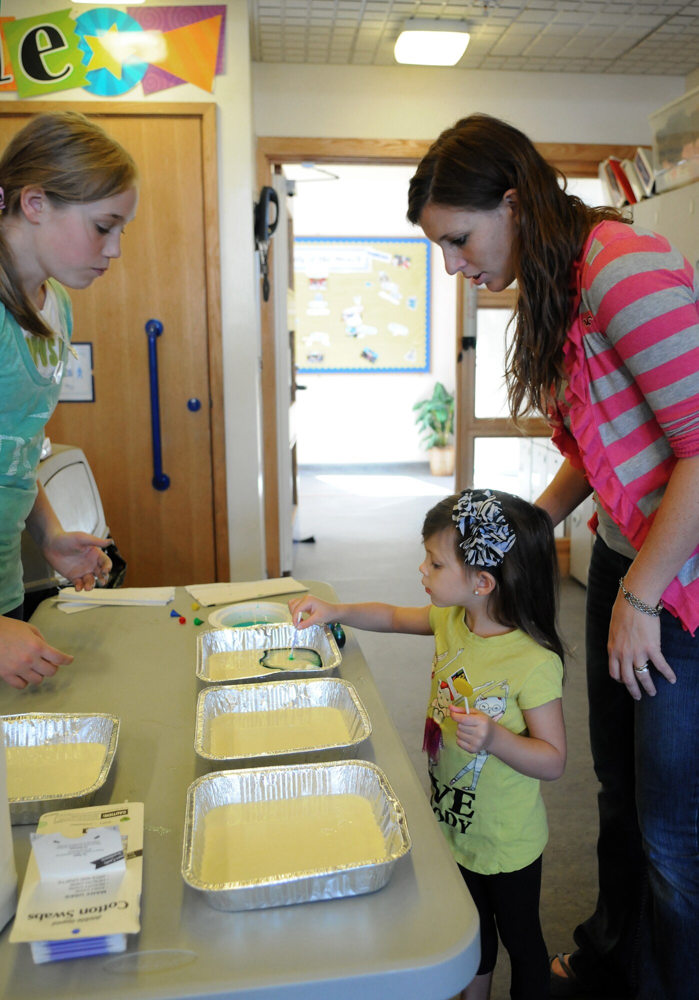RAF MILDENHALL, England -- Faith Quinlisk, left, 12, daughter of Capt. Amy Quinlisk, 48th Medical Operations Squadron, teaches a visual sensory experiment at the Boys and Girls Clubs of America’s Day for Kids celebration Sept. 17, 2011, to Alexis Fontana, 4, and her mother Alicia, wife of Senior Airman Mark Fontana, 352nd Special Operations Maintenance Squadron. Educational stations showed how to use each of the body’s five senses. Other activities at the celebration included pedal cars, a magic show and a visit from the Pets as Therapy charity. (U.S. Air Force photo by Staff Sgt. Thomas Trower)