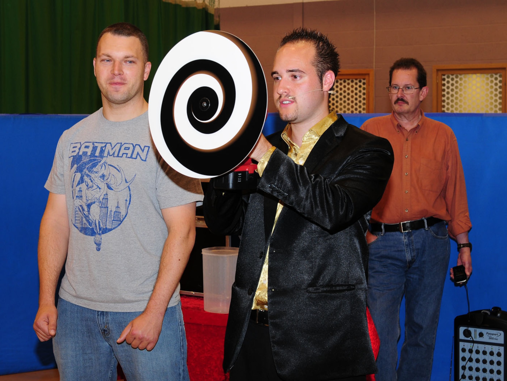 RAF MILDENHALL, England -- Tech. Sgt. Michael Vogel, left, 100th Logistics Readiness Squadron, and Allan Costello, right, 100th Force Support Squadron, help magician Michael Gee with an optical illusion at the Boys and Girls Clubs of America's Day for Kids celebration Sept. 17, 2011, at the youth center here. Other activities included face painting, pedal cars and bouncy castles. The event, held annually, allows children to spend time having fun with their families. (U.S. Air Force photo by Karen Abeyasekere)