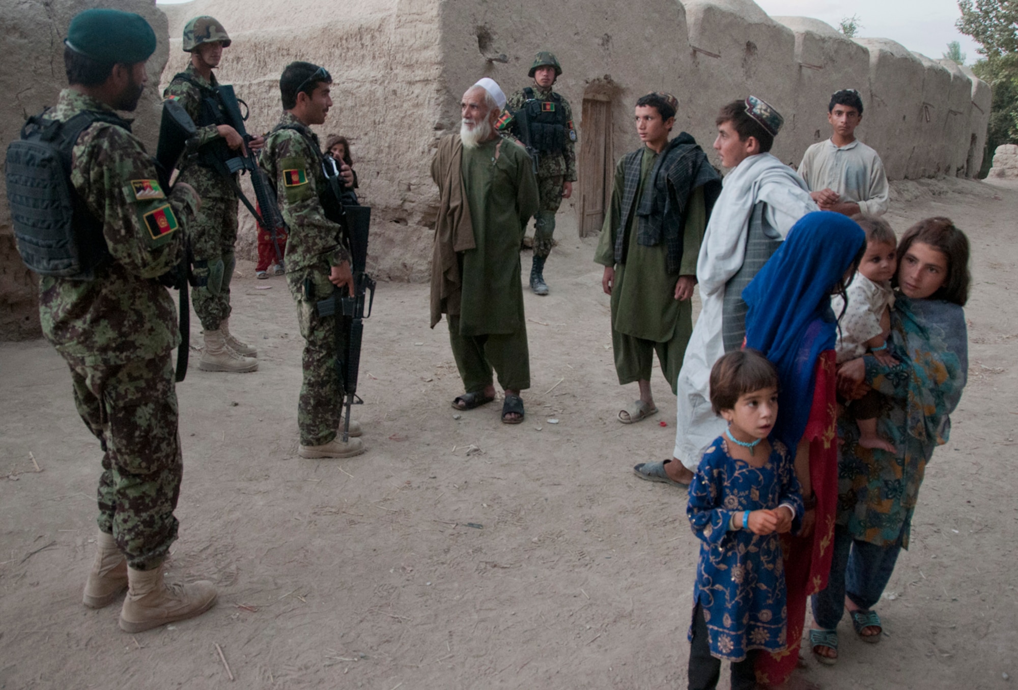 Afghan Air Force security forces airmen from the Kandahar Air Wing talk to residents during an evening foot patrol in a village near Kandahar Airfield, Afghanistan, Sept. 3, 2011. U.S. Air Force security forces advisors train the airmen to provide force protection for KAF as well as the surrounding ground defense area. (U.S. Air Force photo by Senior Airman Jessica Lockoski 


