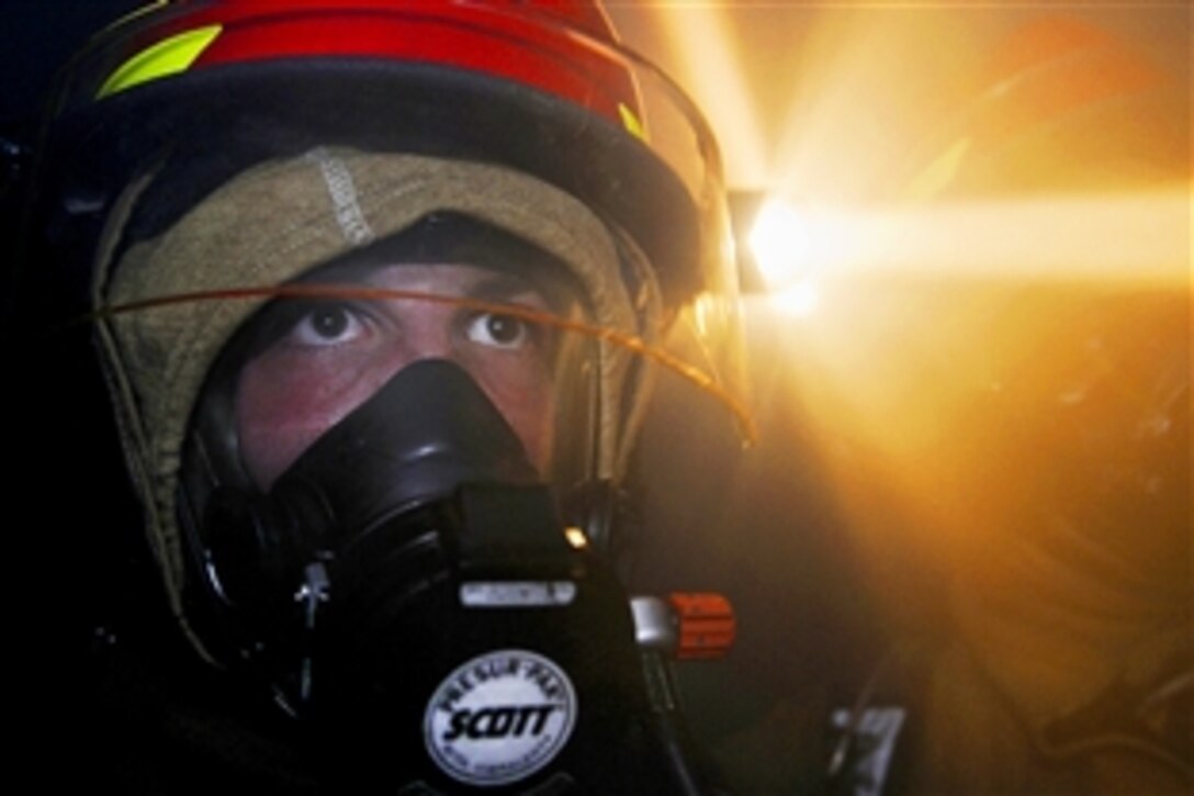 A U.S. sailor practices firefighting during a general quarters drill in the hangar bay aboard the aircraft carrier USS Abraham Lincoln in the Pacific Ocean, Sept. 17, 2011. The Abraham Lincoln is under way conducting an exercise to train all sailors assigned to the ship to function as an effective fighting force.