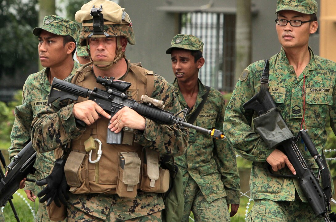 U.S. Marine Staff Sgt. Randy Whitmore, a platoon sergeant from Company A "Animal", 1st Battalion 7th Marines, leads soldiers from Company B, 1st Battalion Singapore Guards through a mock vehicle check point at the Murai Urban Training Facility here Sept. 22 in Singapore. The Marines and sailors from "Animal" Company train alongside soldiers from Company B, 1st Battalion Singapore Guards as part of exercise Valiant Mark 11. Exercise Valiant Mark, in its 10th iteration, is an annual exercise conducted by U.S. Marines and the Singapore Armed Forces in order to maintain a high level of interoperability, enhanced military to military relations and to enrich mutual combat capabilities through combined training.