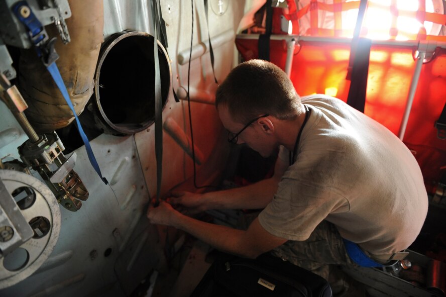 Senior Airman Gregory Beck, 374th Air Maintenance Squadron, Yokota Air Base, Japan, performs transient repair on a C-130 Hercules cargo plane at Kadena Air Base, Japan, Sept. 21. Beck flew from Yokota along with three C-130s that evacuated from Typhoon Roke's path. Airmen from the 18th Operations Group, 18th Logistics Readiness Squadron and 733rd Air Mobility Squadron helped bed-down and receive the aircraft and crews from Yokota during their brief stay here. (U.S. Air Force photo/Airman 1st Brooke P. Beers)