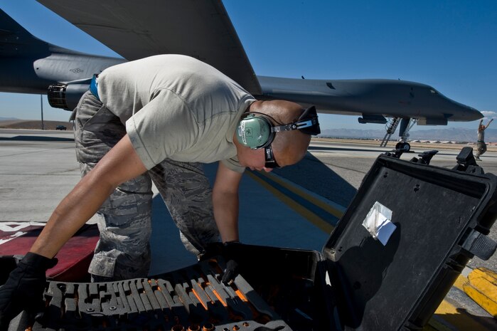 U.S. Air Force Senior Airman Demetrio Gutierrez, 7th Aircraft Maintenance Squadron crew chief, Dyess Air Force Base, Texas, looks for a tool while working on a B-1B Lancer during Green Flag-West 11-10 Sept. 20, 2011, at Nellis AFB. Nev. Green Flag-West provides a realistic close-air support training environment for forces preparing to support worldwide combat operations. (U.S. Air Force photo by Airman 1st Class Daniel Hughes/Released)
