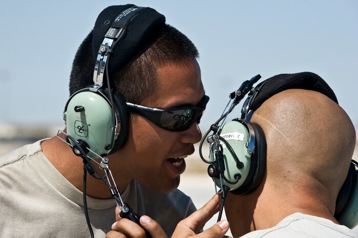 U.S. Air Force Airman 1st Class Oscar Masga and Serior Airman Demetrio Guteirrez, 7th Aircraft Maintenance Squadron crew chiefs, discuss pre-launch procedures prior to marshaling  a B-1B Lancer for a training mission during Green Flag-West 11-10 Sept. 15, 2011, at Nellis AFB, Nev. Green Flag-West provides a realistic close-air support training environment for forces preparing to support worldwide combat operations.(U.S. Air Force photo by Airman 1st Class Matthew Lancaster/Released)