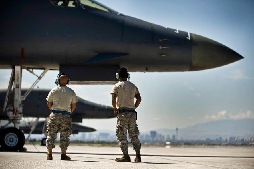 From left, U.S. Air Force Senior Airman Demetrio Gutierrez and Airman 1st Class Oscar Masga, 7th Aircraft Maintenance Squadron crew chiefs, Dyess Air Force Base, Texas, wait to marshal out a B-1B Lancer during Green Flag-West 11-10  Sept. 15, 2011, at Nellis AFB. Nev. Green Flag-West provides a realistic close-air support training environment for forces preparing to support worldwide combat operations.(U.S. Air Force photo by Airman 1st Class Daniel Hughes/Released)