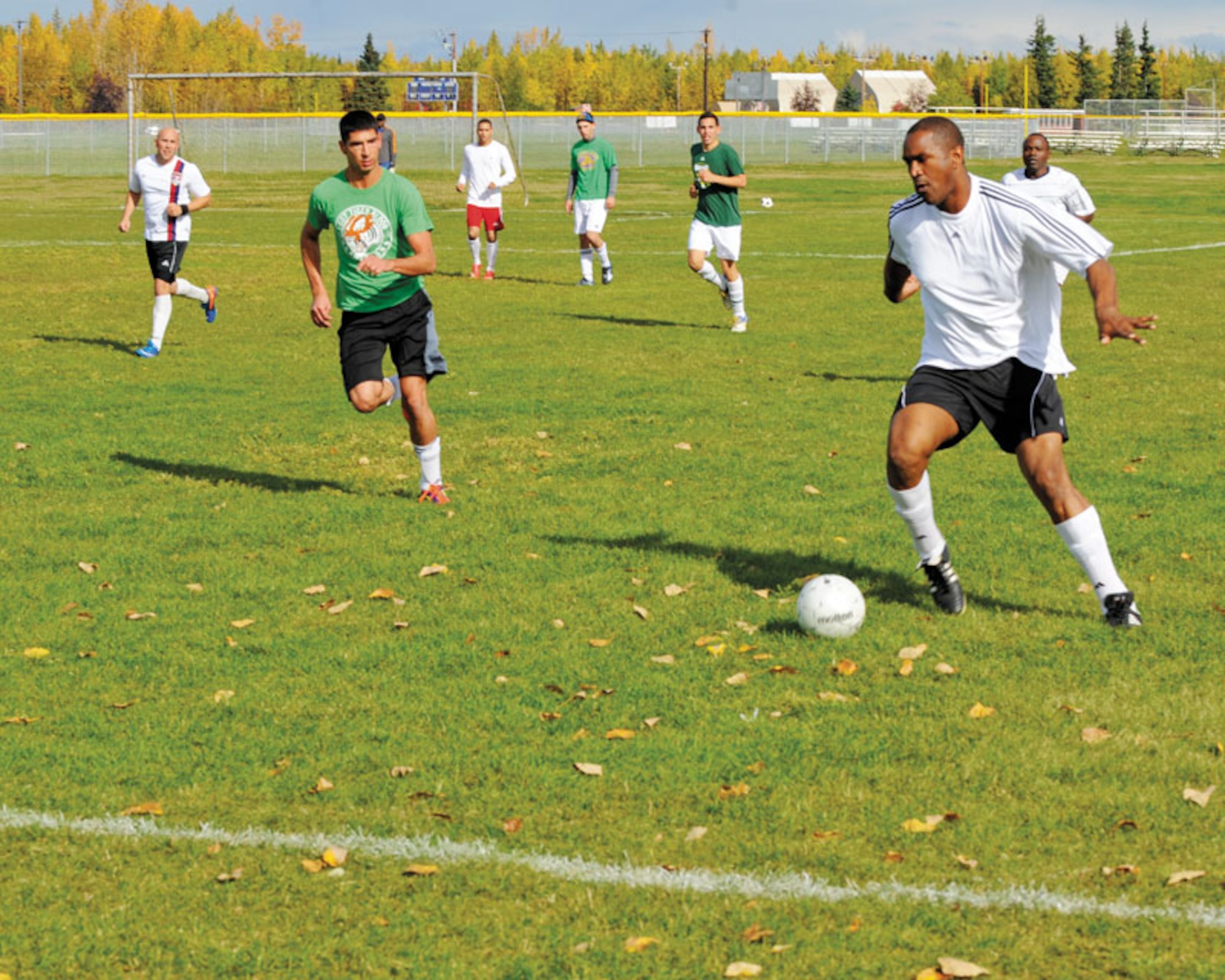 Justin Goodwin of the 673d Medical Group (green shirts) guards a 725th Brigade Support Battalion Soldier Saturday at the Buckner Physical Fitness Center soccer field. The 725th trounced the Airmen with a final score of 6–1.  (U.S. Air Force photo/Steven White)