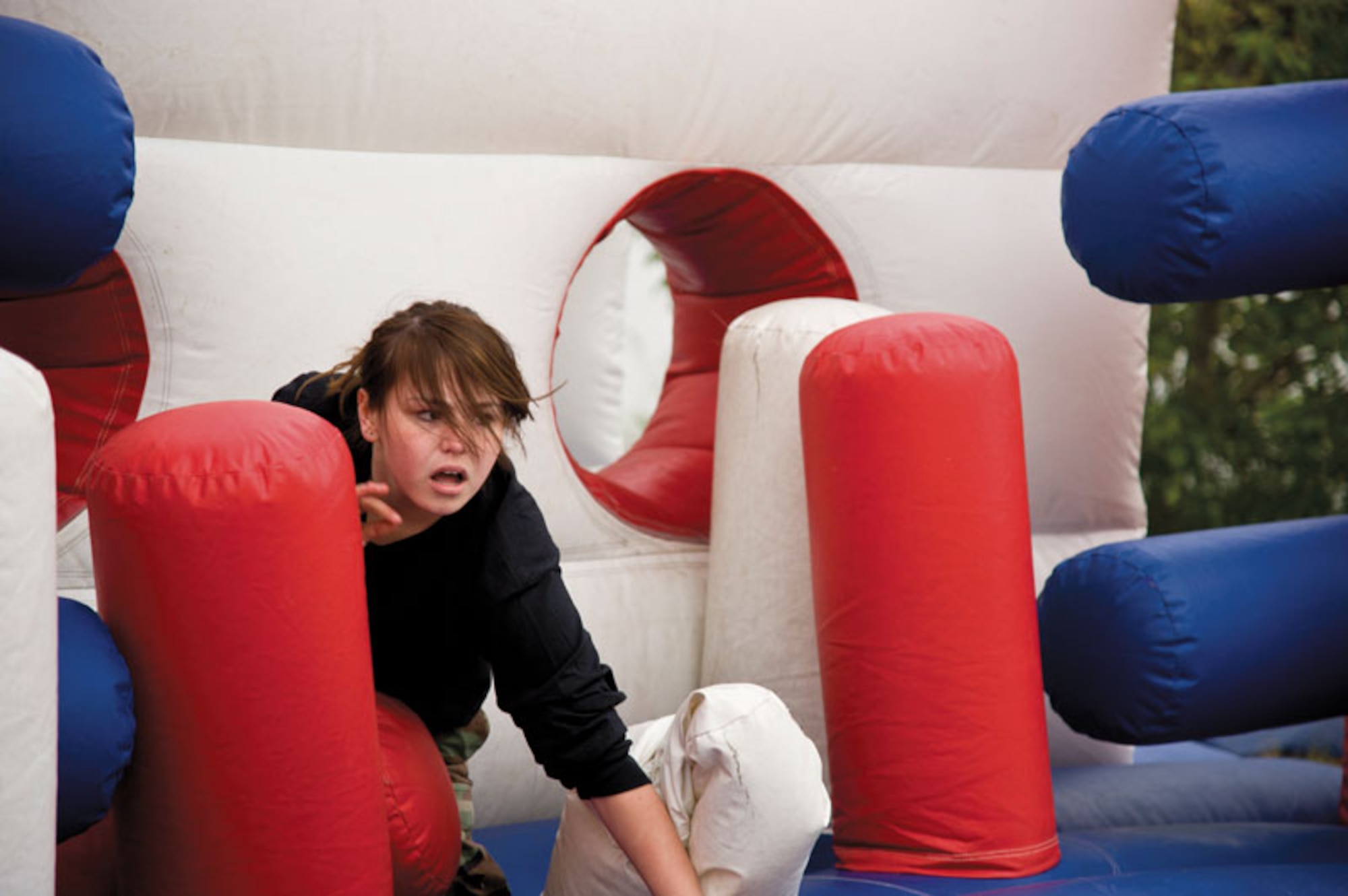 Vanessa Dixon, a sophomore at East High School, makes her way through the beginning of the inflatable obstacle course at the Raider Decathlon Friday. The obstacle course required cadets to jump through openings, make their way around obstacles, and climb a 14-foot ramp before sliding down to the bottom and getting entirely off the course in the shortest time possible.  (U.S. Air Force photo/Johnathon Green)