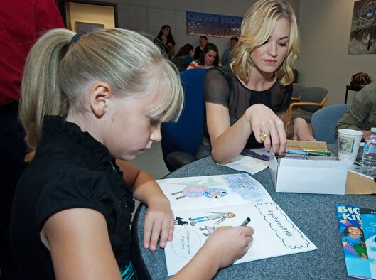 Six year old Piper Walline gets some help coloring from model and "Killer Elite" actress Yvonne Strahovski.  (Air Force photo by Rob Densmore)