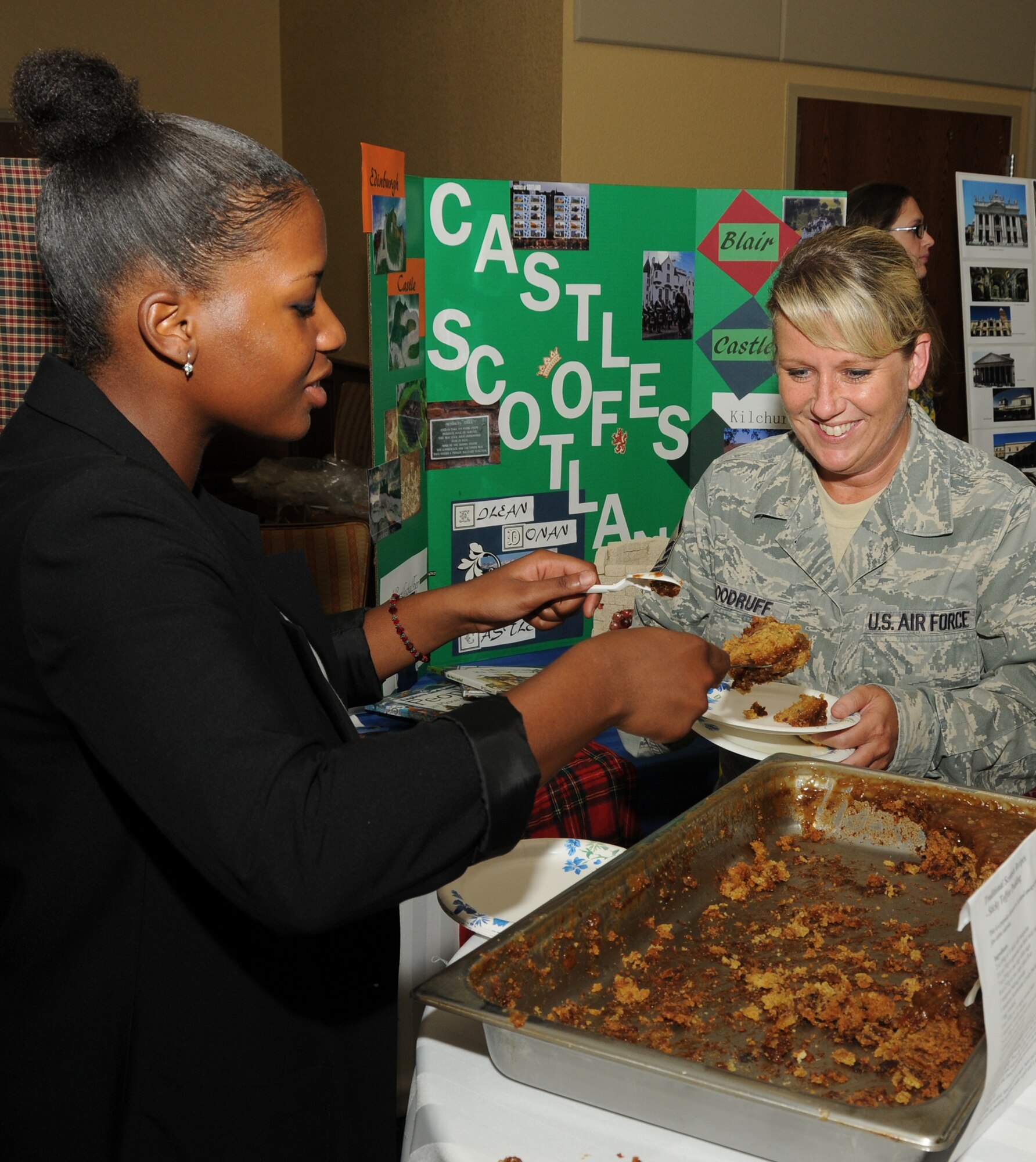 Airman 1st Class Tiffany Blake, 81st Medical Operations Squadron, serves sticky toffee pudding, a Scottish dessert, to Master Sgt. Jessica Woodruff, 81st Force Support Squadron, at Diversity Day, Sept. 13 at the Bay Breeze Event Center.  The cultural celebration included music, literature, dancing, poetry, face painting, games and food for children and adults.   (U.S. Air Force photo by Kemberly Groue)