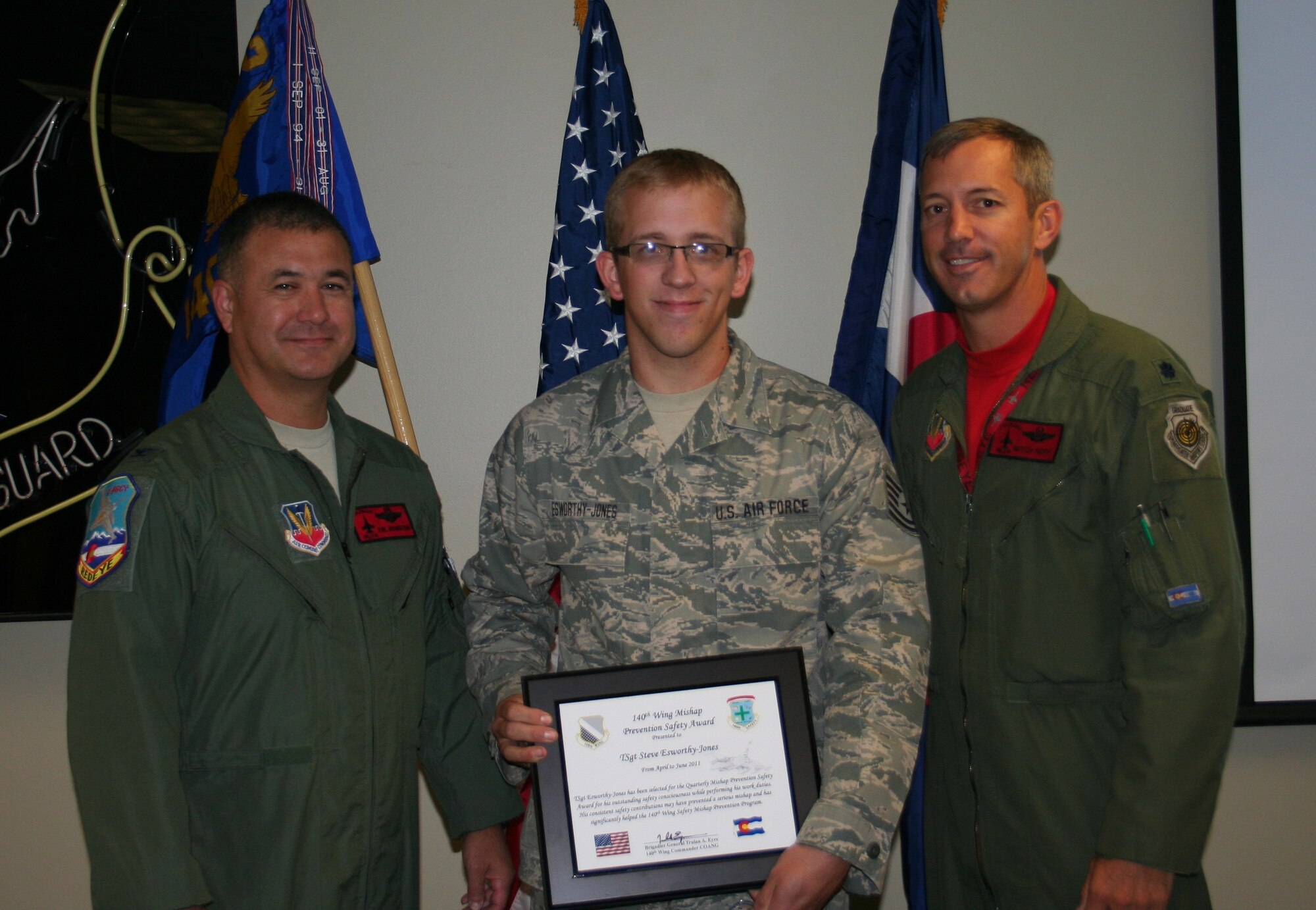 Col. Floyd Dunstan, 140th Wing vice commander, and Lt. Col. Mitchell Neff, 140th Wing chief of safety, present Tech. Sgt. Steve Esworthy-Jones with the Quarterly Mishap Prevention Safety Award for his outstanding safety consciousness while performing his work duties. (U.S. Air Force Photo)