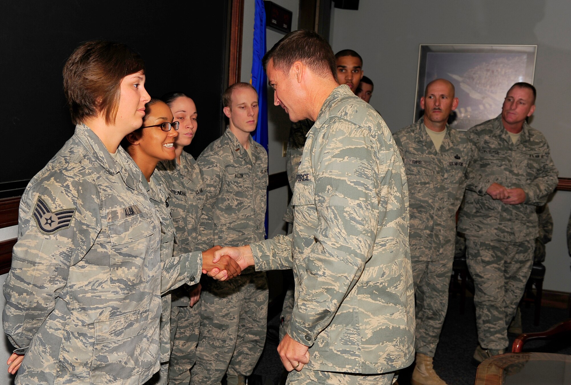 U.S. Air Force Col. Charlie Moore, 20 Fighter Wing commander, shakes hands with Senior Airman Tanya Sipos, 20th Force Support squadron reenlistment counselor, Shaw Air Force Base, S.C., Sept. 19, 2011. Sipos along with seven others were coined by Moore for their excellent performance during the 9/11 ceremony.  (U.S. Air Force photo by Airman 1st Class Neil D. Warner/Released)