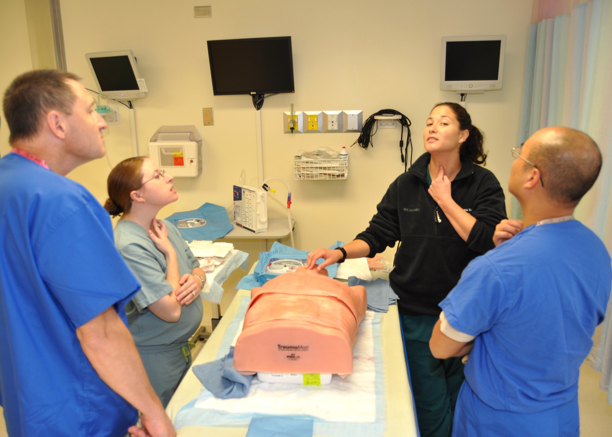 General surgery resident Capt. (Dr.) Andrea Blake, 81st Surgical Operations Squadron,
second from right, demonstrates both on herself and a mannequin where to make an incision to place a breathing tube in a patient’s throat during the ATLS course. Students are, from left, Lt. Col. (Dr.) Richard Liotta, a reservist assigned to the 94th Aeromedical Staging Squadron at Dobbins Air Reserve Base, Ga.; and Capts. (Drs.) Lauren Herrmann and Minh Ho, 81st Medical Operations Squadron.  (U.S. Air Force photo by Steve Pivnick)