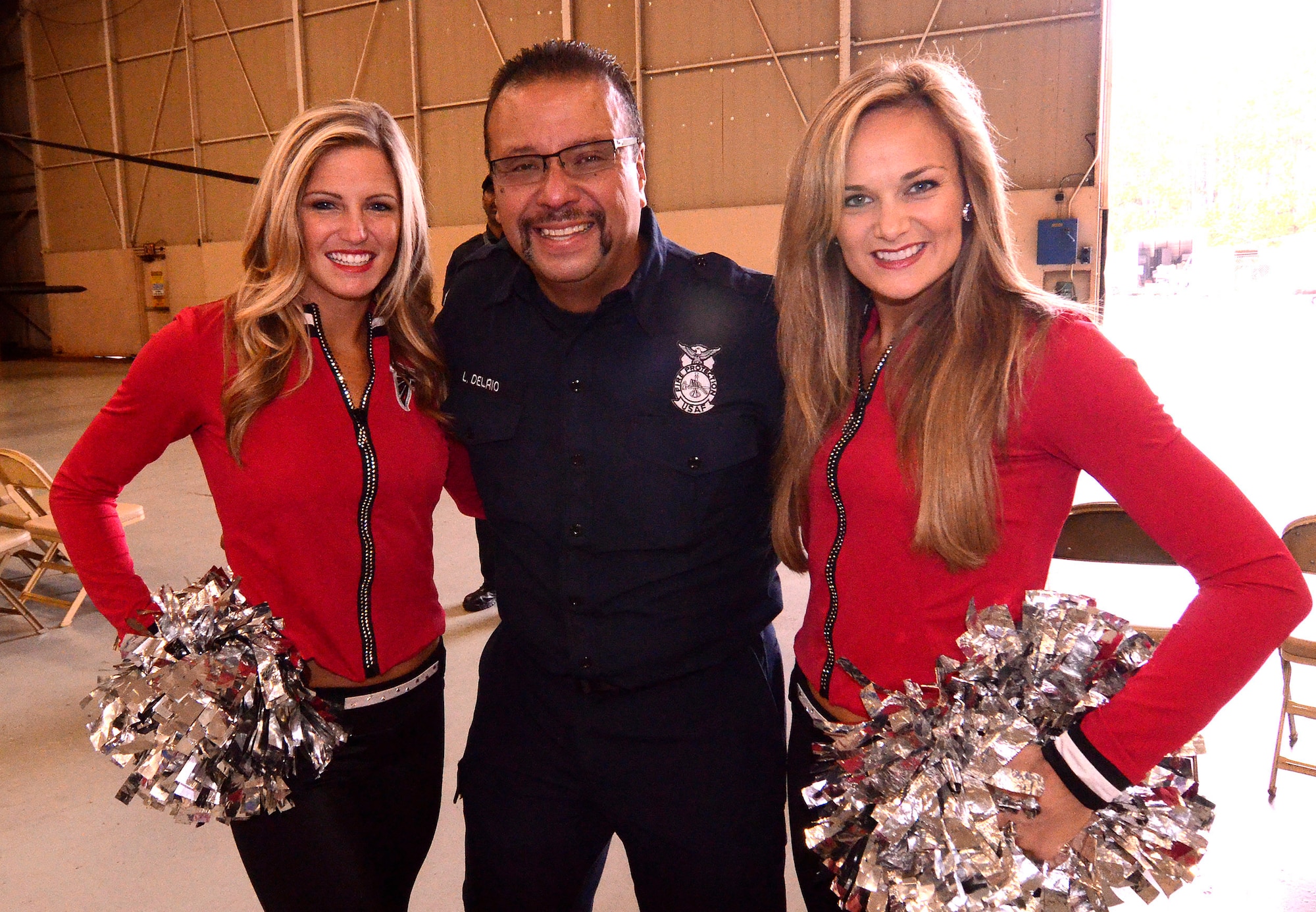 Luis Del Rio, 94th Airlift Wing firefighter, poses with cheerleaders Sabrina and Brandy of the Atlanta Falcons at Dobbins Air Reserve Base, Sept. 20. The football team members came to Dobbins to show their appreciation for what the military does every day.   (U.S. Air Force photo/ Brad Fallin)