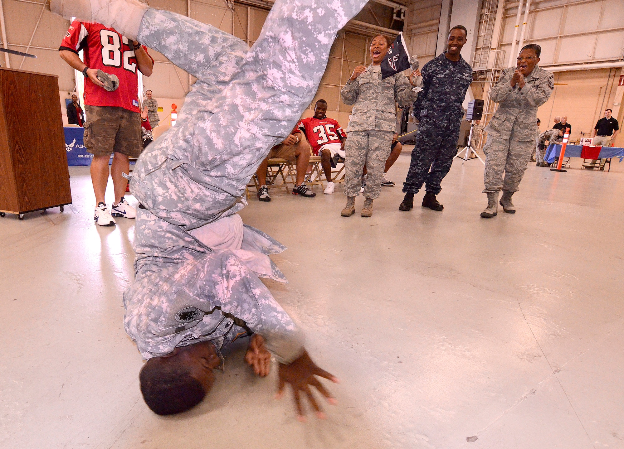 Staff Sgt. Tony Sailor, 78th Homeland Response Force, performs his best touchdown victory dance after being coaxed by tight end, Joe Zelenka of the Atlanta Falcons at Dobbins Air Reserve Base, Sept. 20. The football team members came to Dobbins to thank military members for their service.   (U.S. Air Force photo/ Brad Fallin)