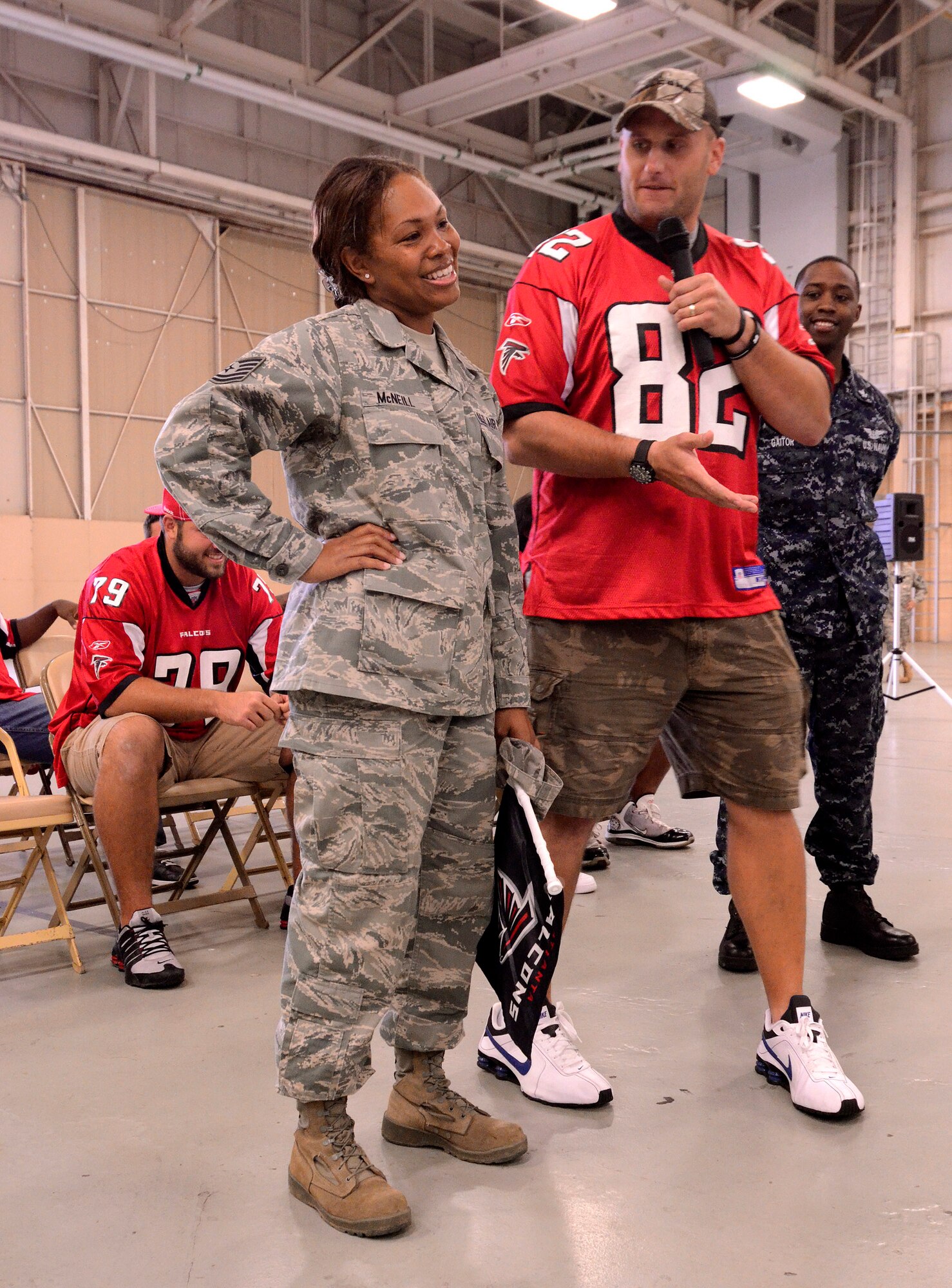 Tech. Sgt. Shakela McNeill, 951st AFRC/A1, is being coaxed by Tight End, Joe Zelenka of the Atlanta Falcons, to perform her best touchdown victory dance for the crowd at Dobbins Air Reserve Base, Sept. 20. The football team members came to Dobbins to thank military members for their service.   (U.S. Air Force photo/ Brad Fallin)