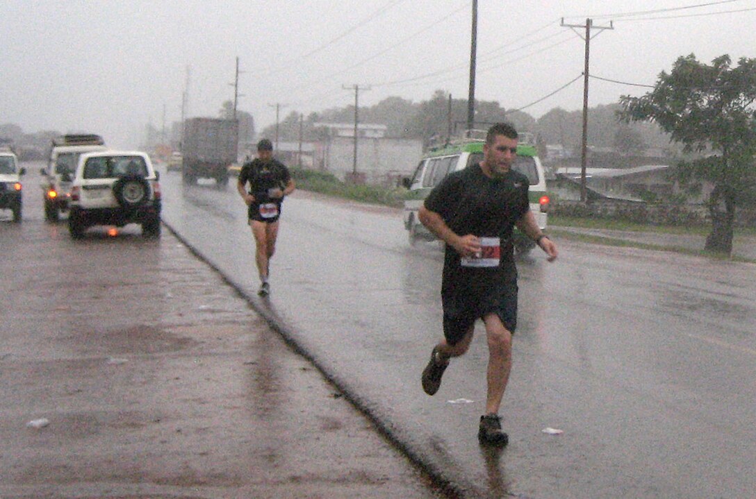 Staff Sgt. Mauricio Pasquale, 633rd Medical Operations Squadron medical technician, runs through a torrential downpour during the first Liberian Marathon Aug. 28, 2011. Pasquale is deployed to West Africa as part of Operation Onward Liberty. (Courtesy photo)