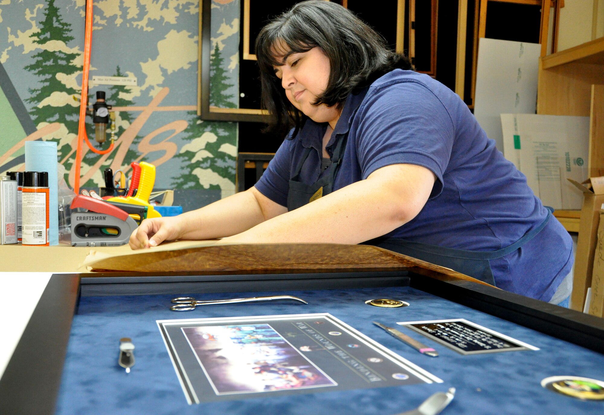 Tricia Jagger, Travis Arts and Crafts Center assistant director and class programmer, puts the finishing touches on a framing job Monday at the Custom Frame Shop. (U.S. Air Force photo/Staff Sgt. Timothy Boyer)