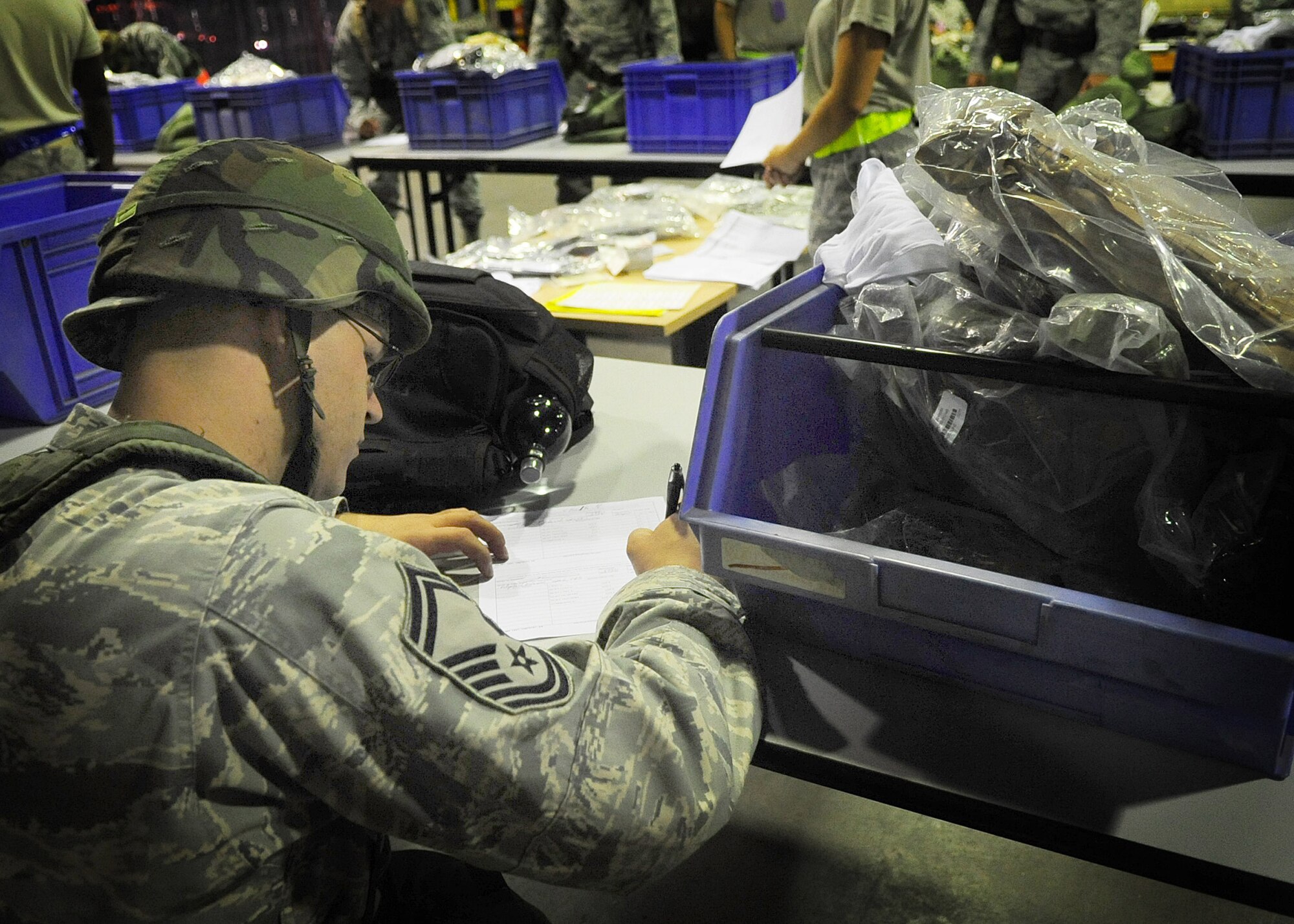 An Airman signs a form while in the processing deployment function line as part of an Operational Readiness Exercise Sept. 21 at Aviano Air Base, Italy.  Aviano Airmen are participating in an ORE, a training tool that ensures Airmen are ready to deploy and work in deployed locations. (U.S. Air Force Photo/ Senior Airman Evelyn Chavez)