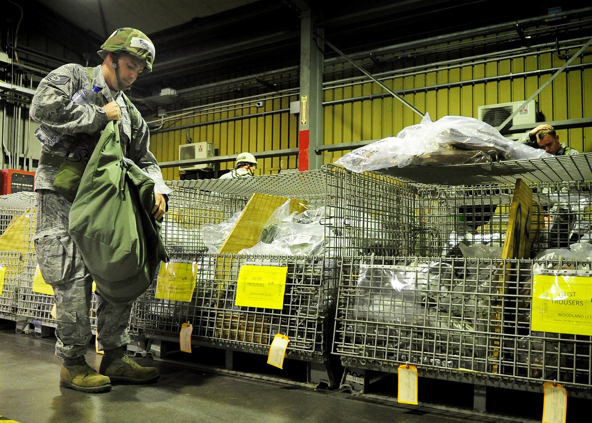 An Airman picks up chemical gear after processing through a simulated processing deployment function line as part of an Operational Readiness Exercise Sept. 21 at Aviano Air Base, Italy.  Aviano Airmen are participating in an ORE, a training tool that ensures Airmen are ready to deploy and work in deployed locations. (U.S. Air Force Photo/ Senior Airman Evelyn Chavez)