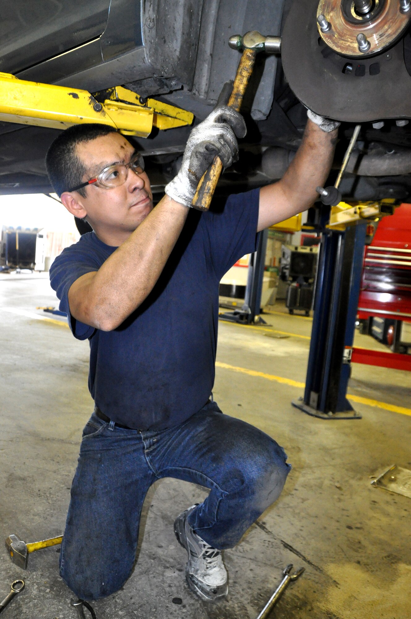 Paul Ang, brother in-law of Master Sgt. Abner Ramos. 60th Civil Engineer Squadron, uses a lift Monday at the Auto Hobby Shop to replace the wheel bearings on his car. (U.S. Air Force photo/Staff Sgt. Timothy Boyer)