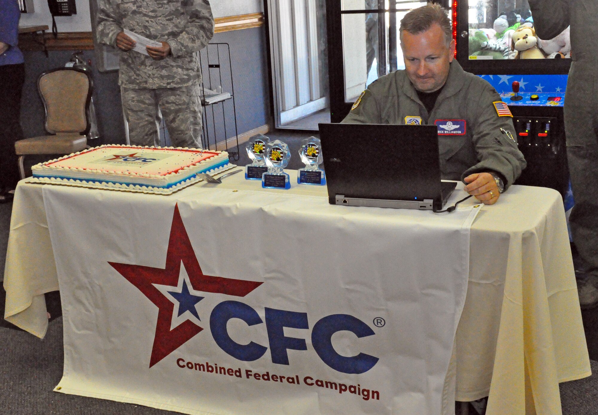 Col. Richard Williamson, 60th Air Mobility Wing vice commander, begins the combined federal campaign by being the first to pledge and donate at the 2011 CFC bowl-a-thon and also demonstrates how hassle-free it is to give online for donors. (U.S. Air Force photo/ Airman Madelyn Ottem)
