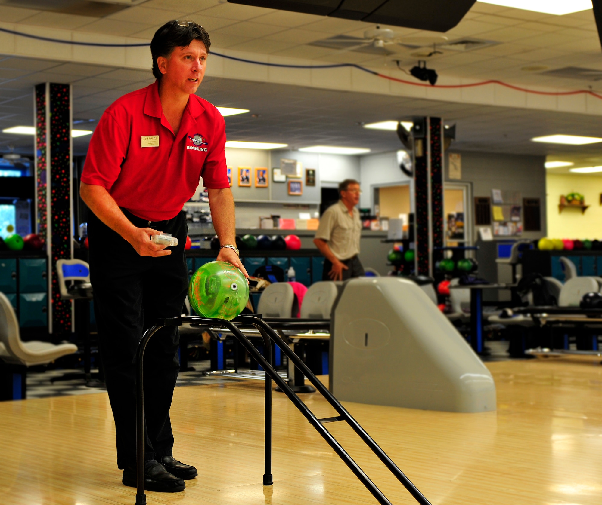 Horace Garrison, 20th Force Support Squadron bowling center manager, pushes the remote control bowling ball down the ramp at the bowling center at Shaw Air Force Base, S.C. Sept. 20, 2011. The remote control ball allows those that are disabled to still experience the joys of bowling. (U.S. Air Force photo/ Airman 1st Class Daniel Phelps/Released)