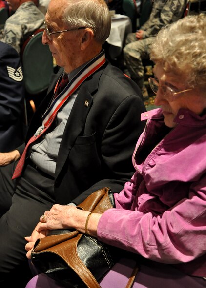 A former prisoner of war holds his wife’s hand while listening to guest speaker retired Col. Larry Writer during the Prisoner of War/Missing in Action Recognition Day luncheon at the McChord Field Club Sept. 16, 2011, at Joint Base Lewis-McChord, Wash. (U.S. Air Force photo/Airman 1st Class Leah Young)