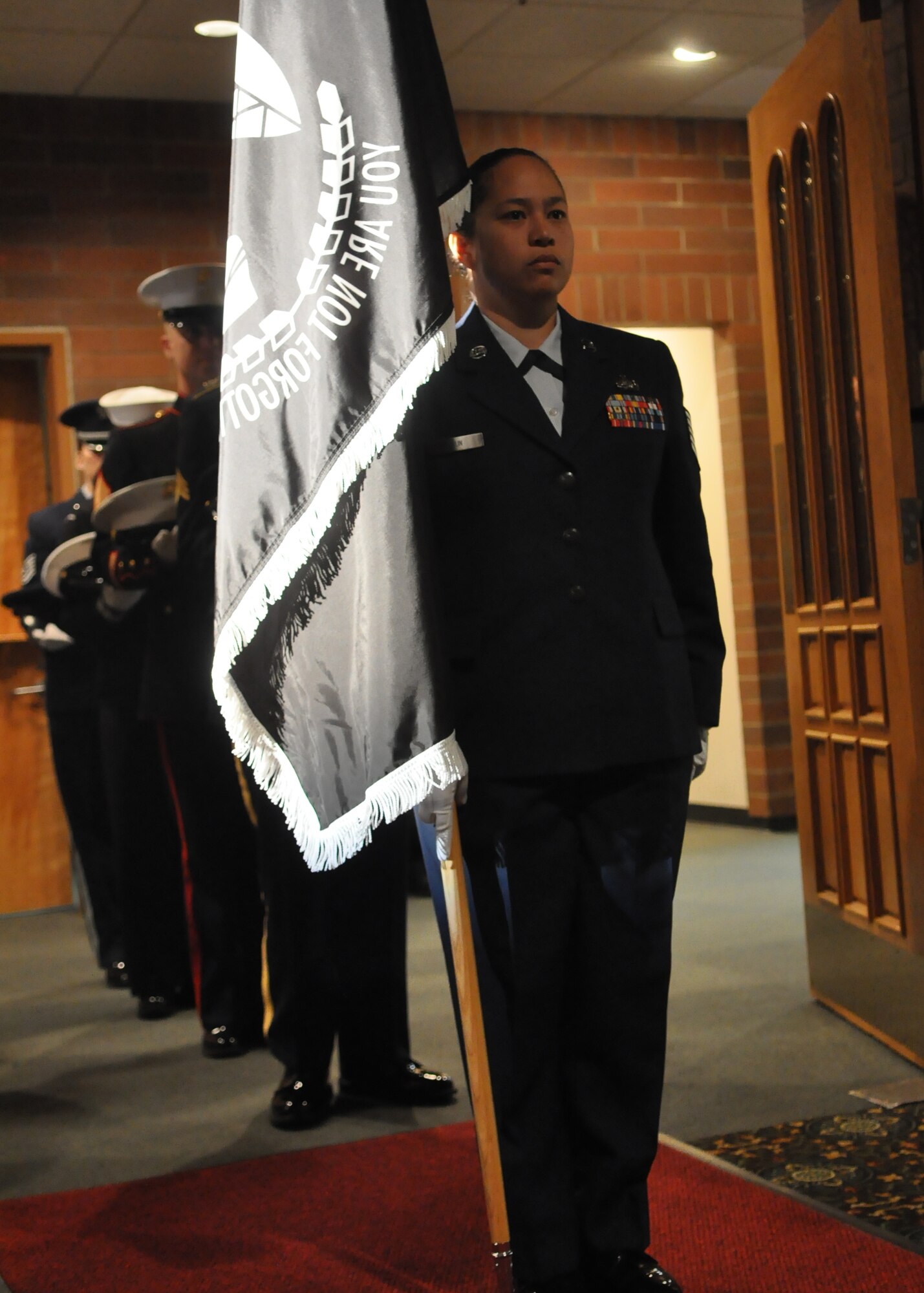 The Prisoner of War/Missing in Action flag is delivered to the front of the room before the start of the POW/MIA Recognition Day luncheon at the McChord Field Club Sept.  16, 2011, at Joint Base Lewis-McChord, Wash. The U.S. remains steadfast in the resolve for a full accounting of what happened to all comrades in arms. (U.S. Air Force photo/Airman 1st Class Leah Young)