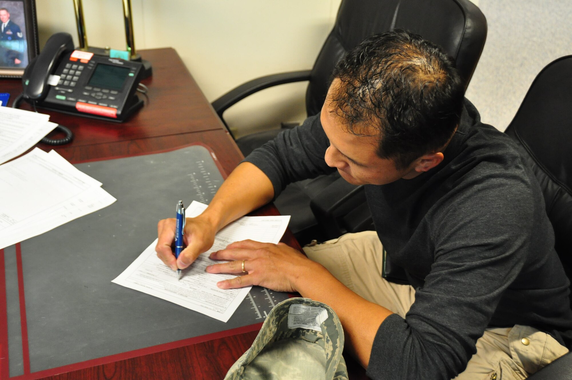 Master Sgt. Chris Westfall, 934th Airlift wing recruiter, finishes enlistment paperwork for Ty Yang, becaming the first Minneapolis line recruiter to hit the Century Club milestone Sept. 16. The award is for recruiters who have placed 100 or more people in the Air Force and is earned by only 10 percent of all recruiters in their career. (Air Force Photo/Tech. Sgt. Jeffrey Williams)